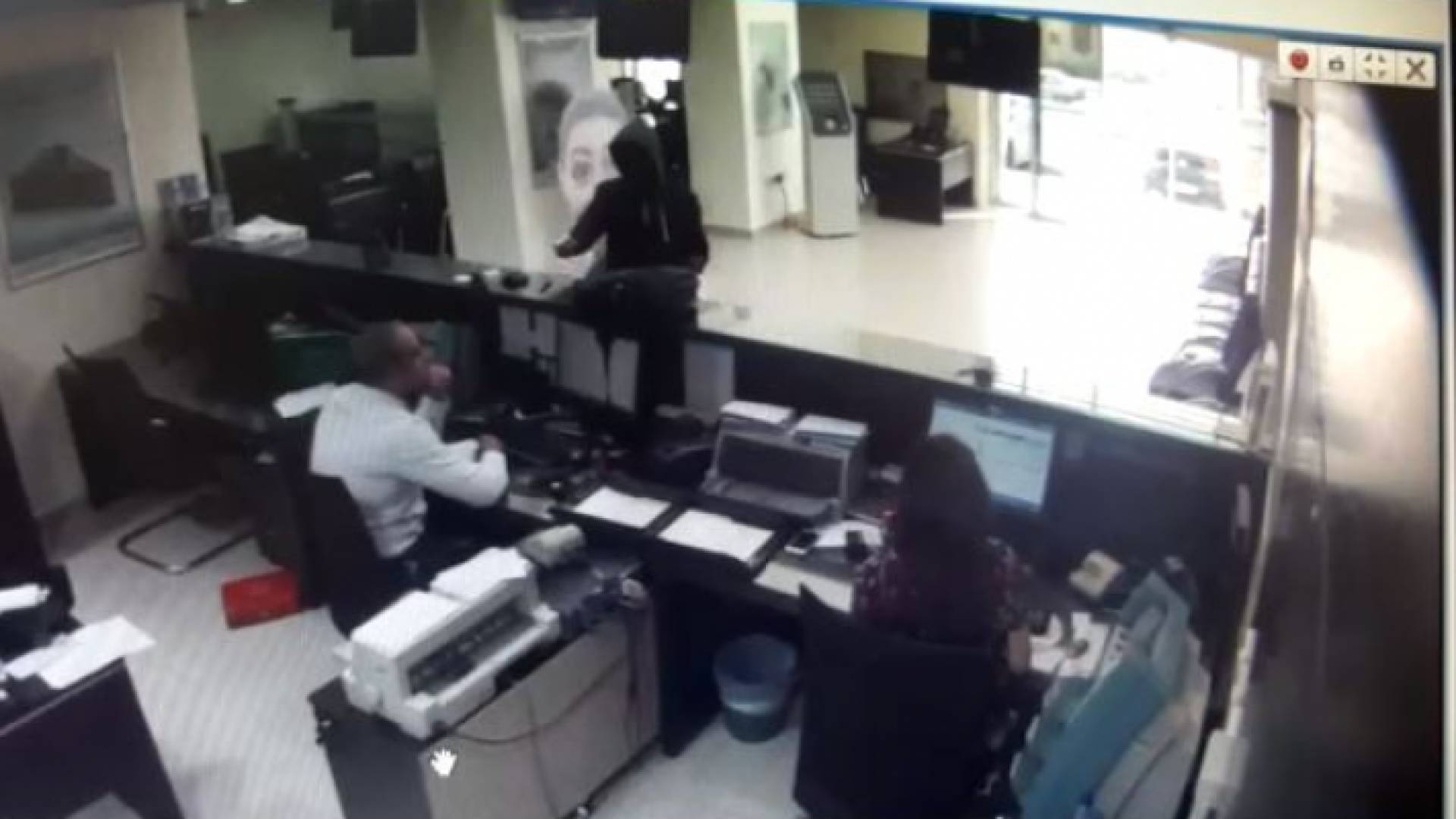 منفذ العملية يشهر سلاحه بوجه موظفي البنك ( خاص برؤيا)