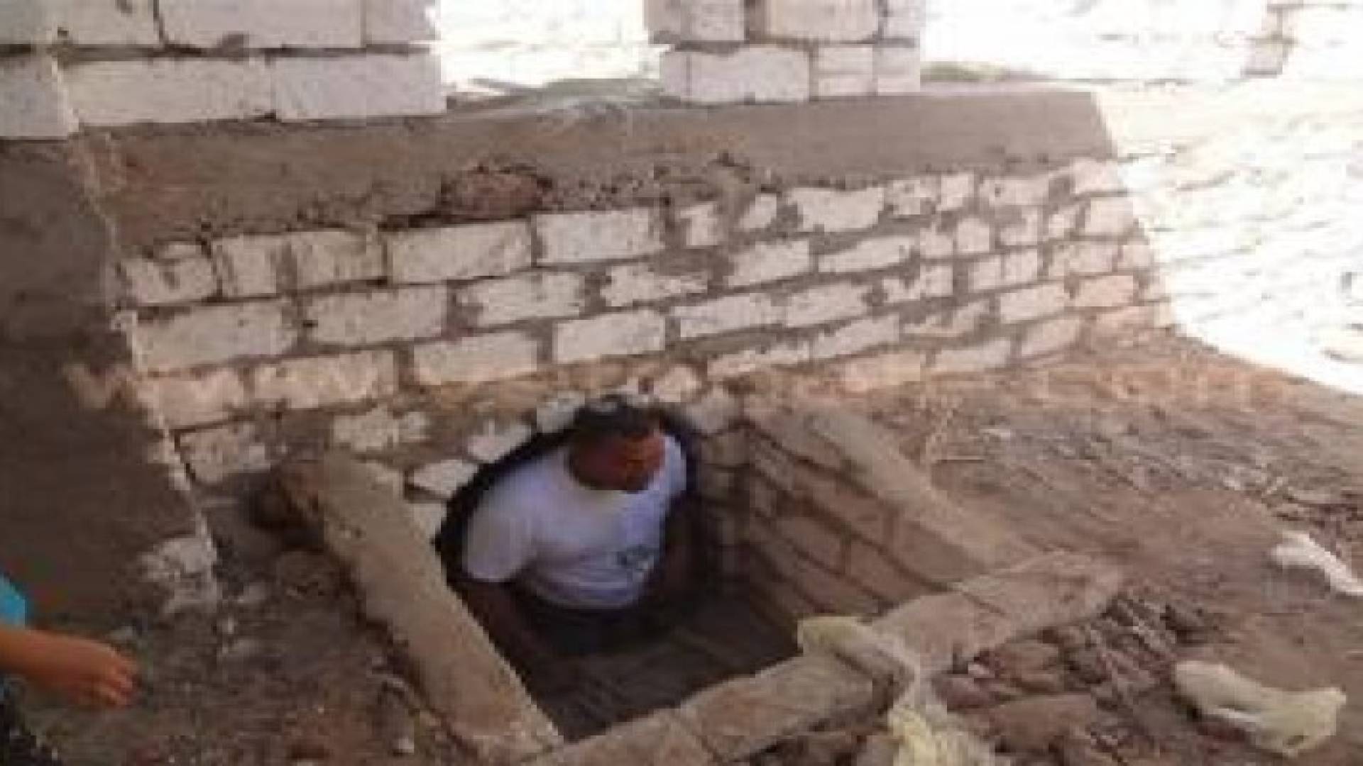 بالصور .. مسؤول مصري يفتح قبر والديه ويجلس معهما