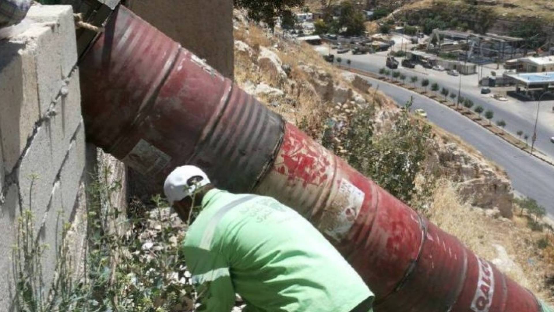 عمان: انابيب حديدية من البراميل لمعالجة طرح النفايات بالسفوح الجبلية .. صور