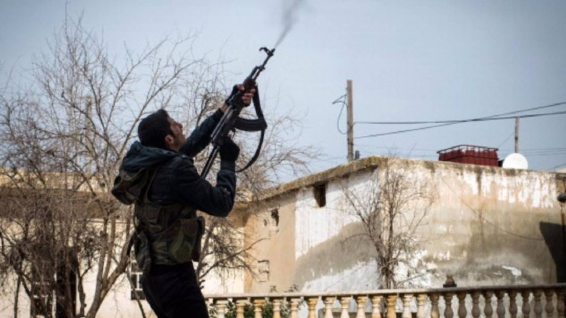 مقاتل من المعارضة يطلق نيران سلاحه صوب مروحية سورية