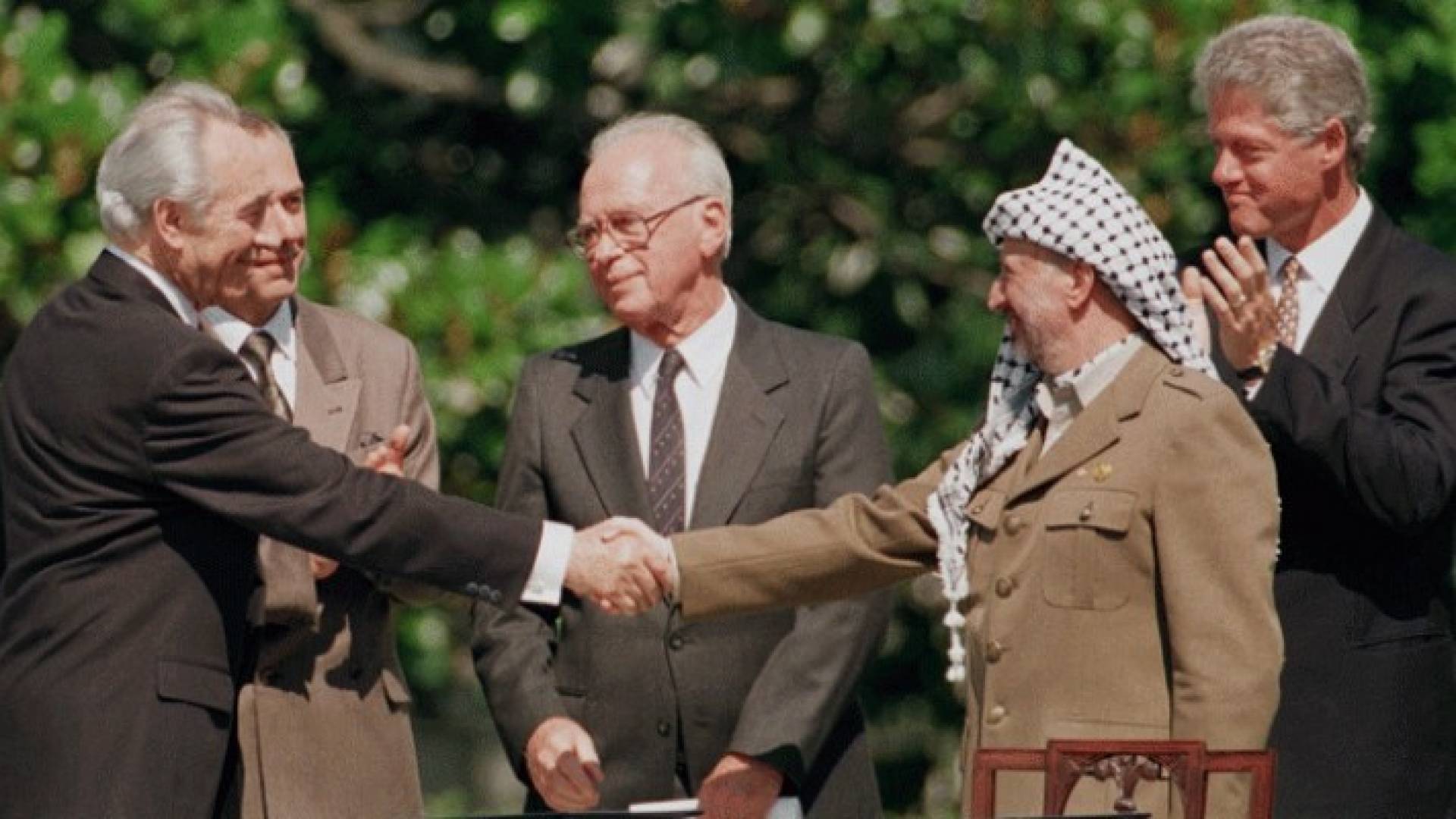 الرئيس الفلسطيني الراحل والرئيس الاسرائيلي السابق شيمون بيريز  يتصافحان 