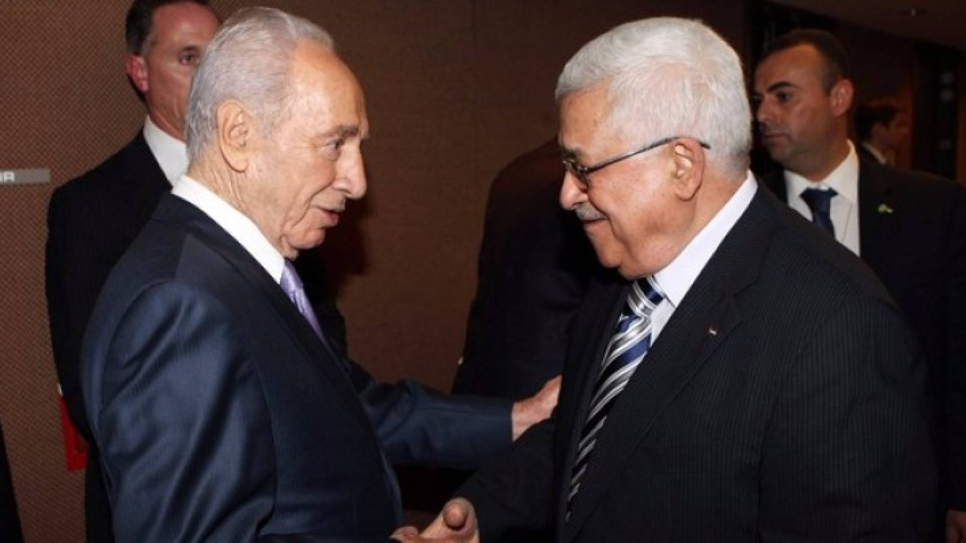 الرئيس الفلسطيني  والرئيس الاسرائيلي السابق شيمون بيريس يتصافحان - أرشيفية