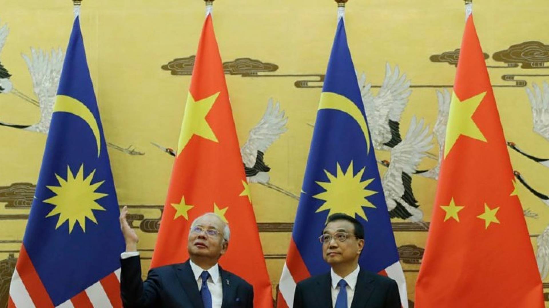 نجيب عبد الرزاق يرفع يده خلال أحد مراسم زيارته إلى الصين