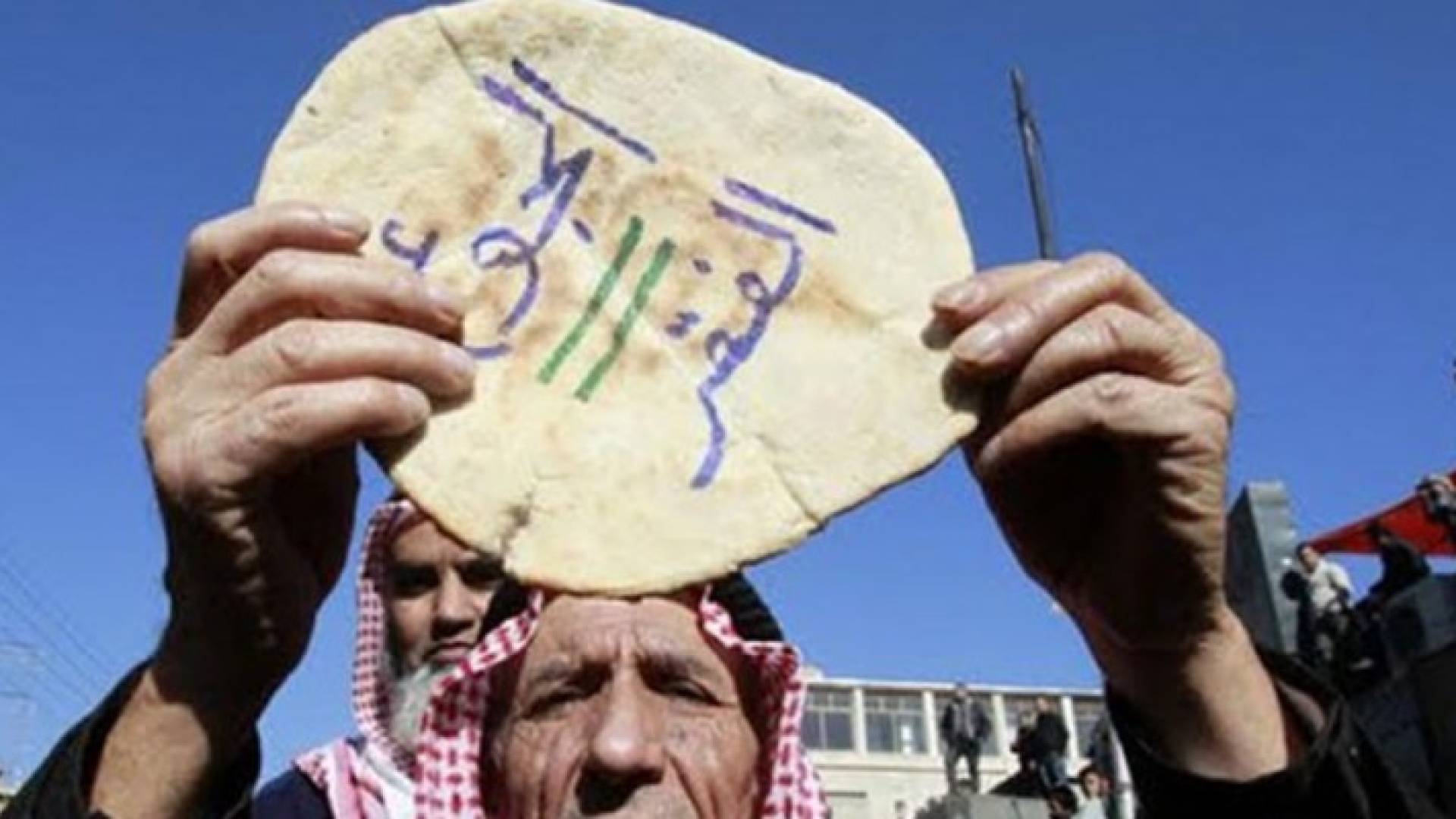 مواطن اردني يرفع رغيف خبز خلال مسيرة سابقة احتجاجاص على رفع الاسعار 