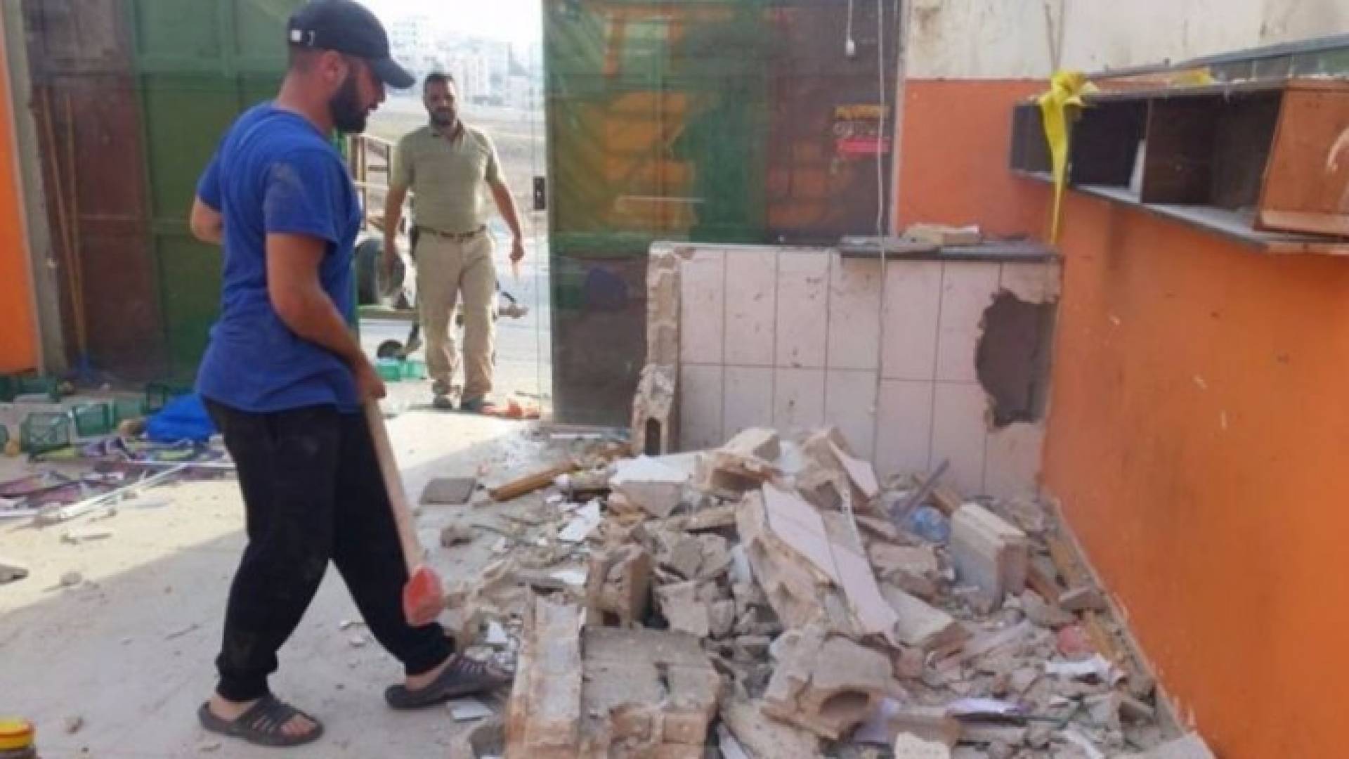 تاجرين مقدسيين يهدمان محليهما في حي بيت حنينا