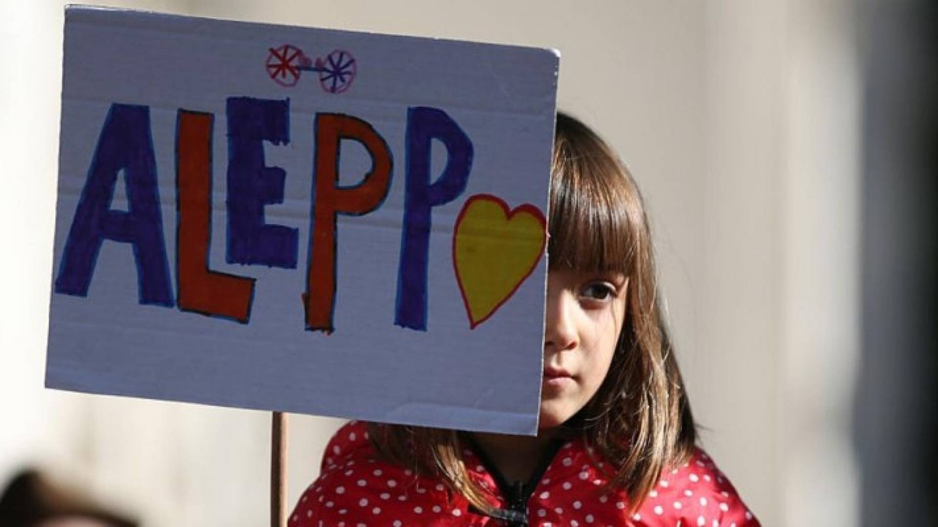  فتاة تحمل لافتة في تظاهرة في لندن تدعو بريطانيا للتدخل لوقف الأزمة الإنسانية في سوريا