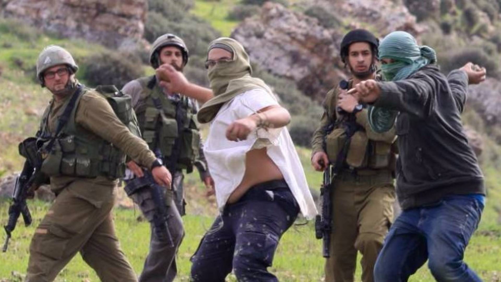 مستوطنون برفقة قوات الاحتلال يرشقون فلسطينيين بالحجارة - أرشيفية