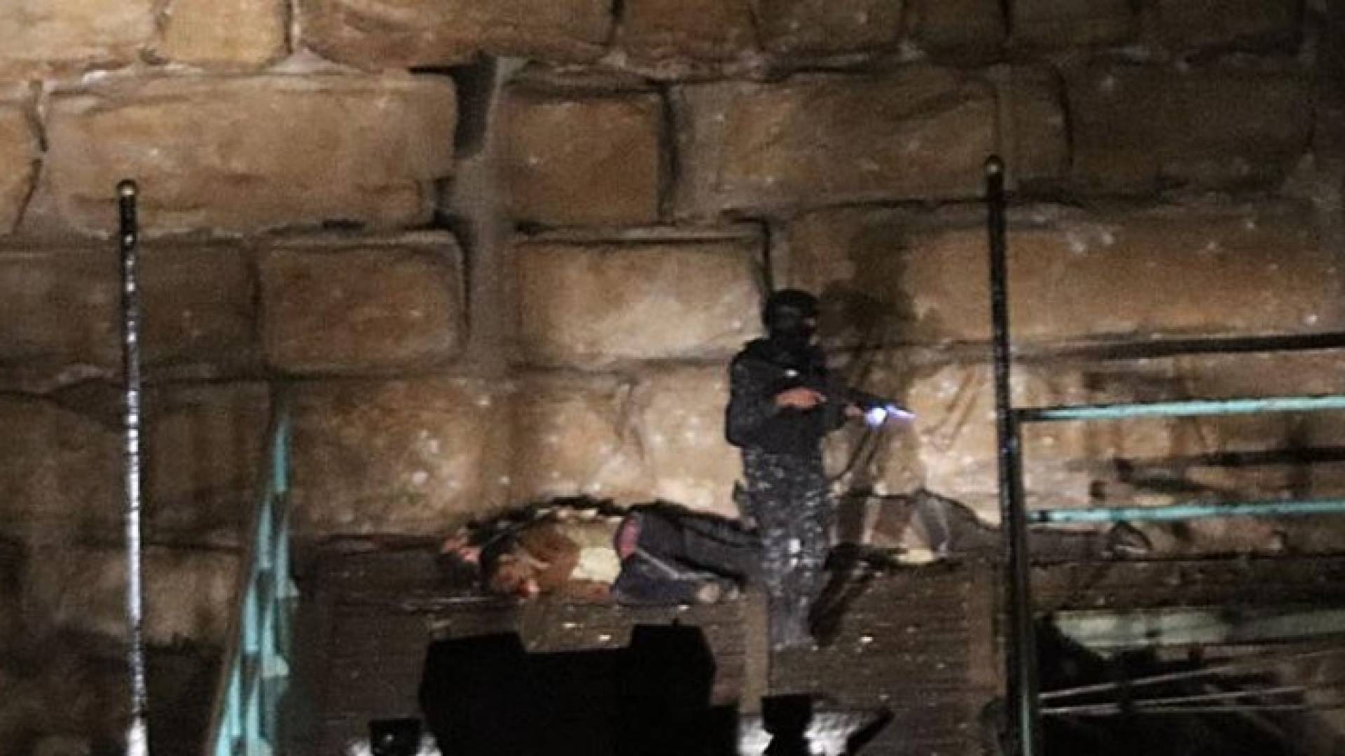 أحد عناصر الأمن بالقرب من جثث المسلحين في قلعة الكرك 