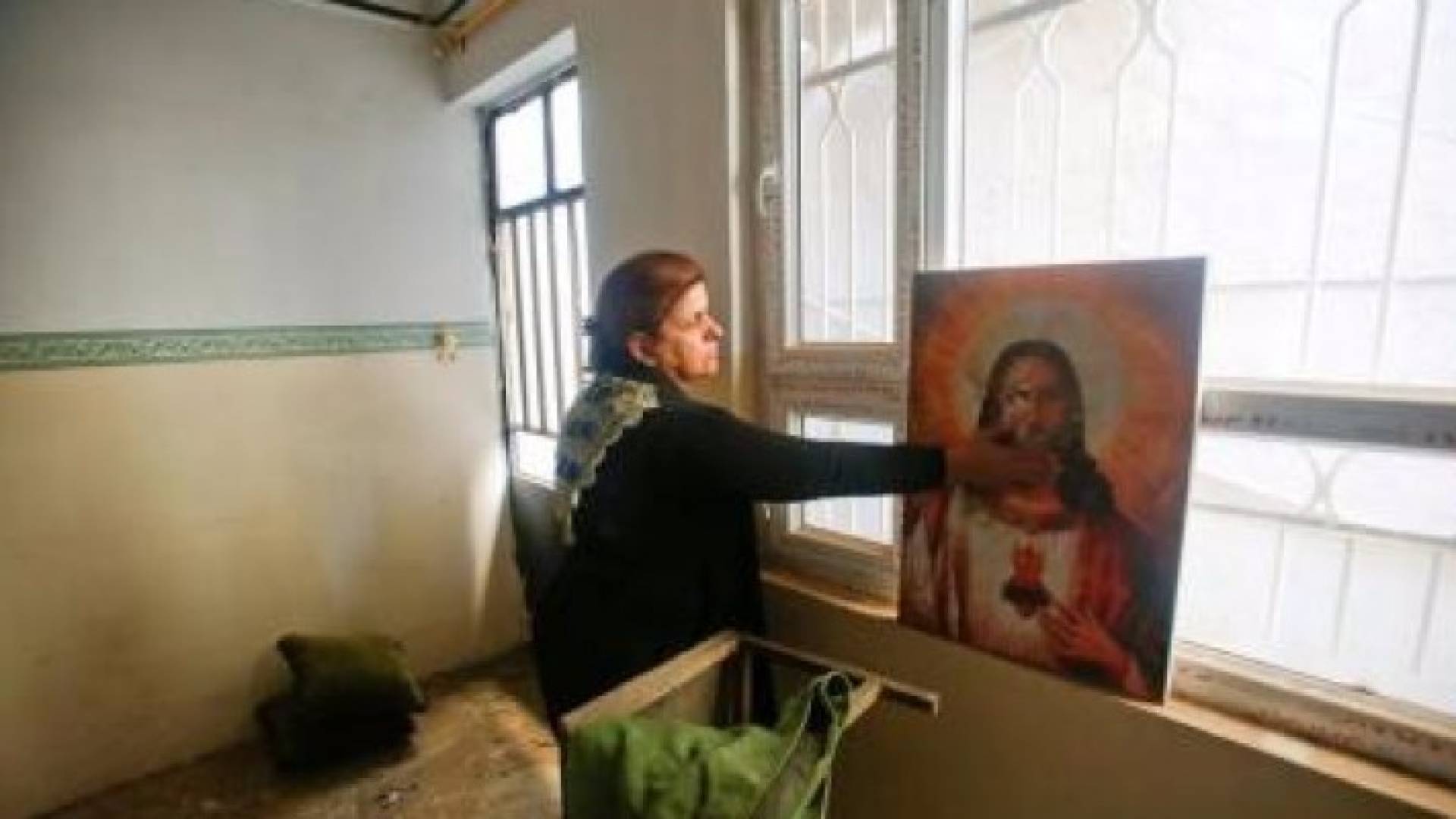 امرأة مسيحية في منزلها ببلدة برطلة شرق الموصل - رويترز