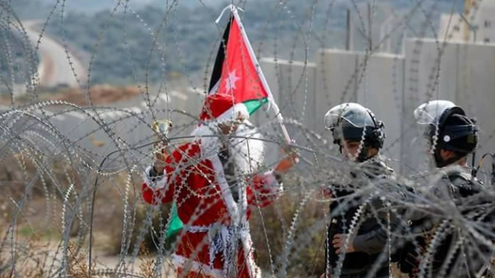 شاب فلسطيني يرفع علم الأردن خلال مظاهرات غرب رام الله 