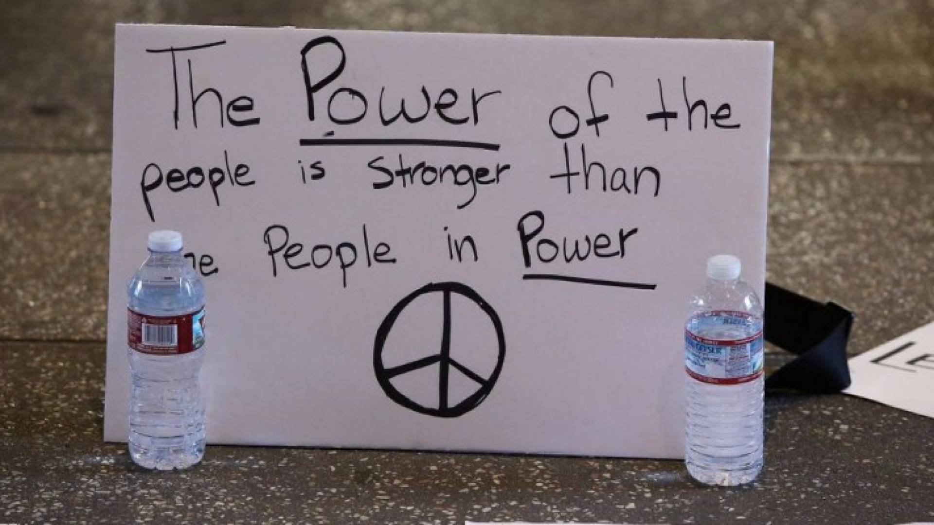 لافتة احتجاج ضد قرار ترامب تقول: قوة الشعب أقوى من أولئك الذين يملكون القوة