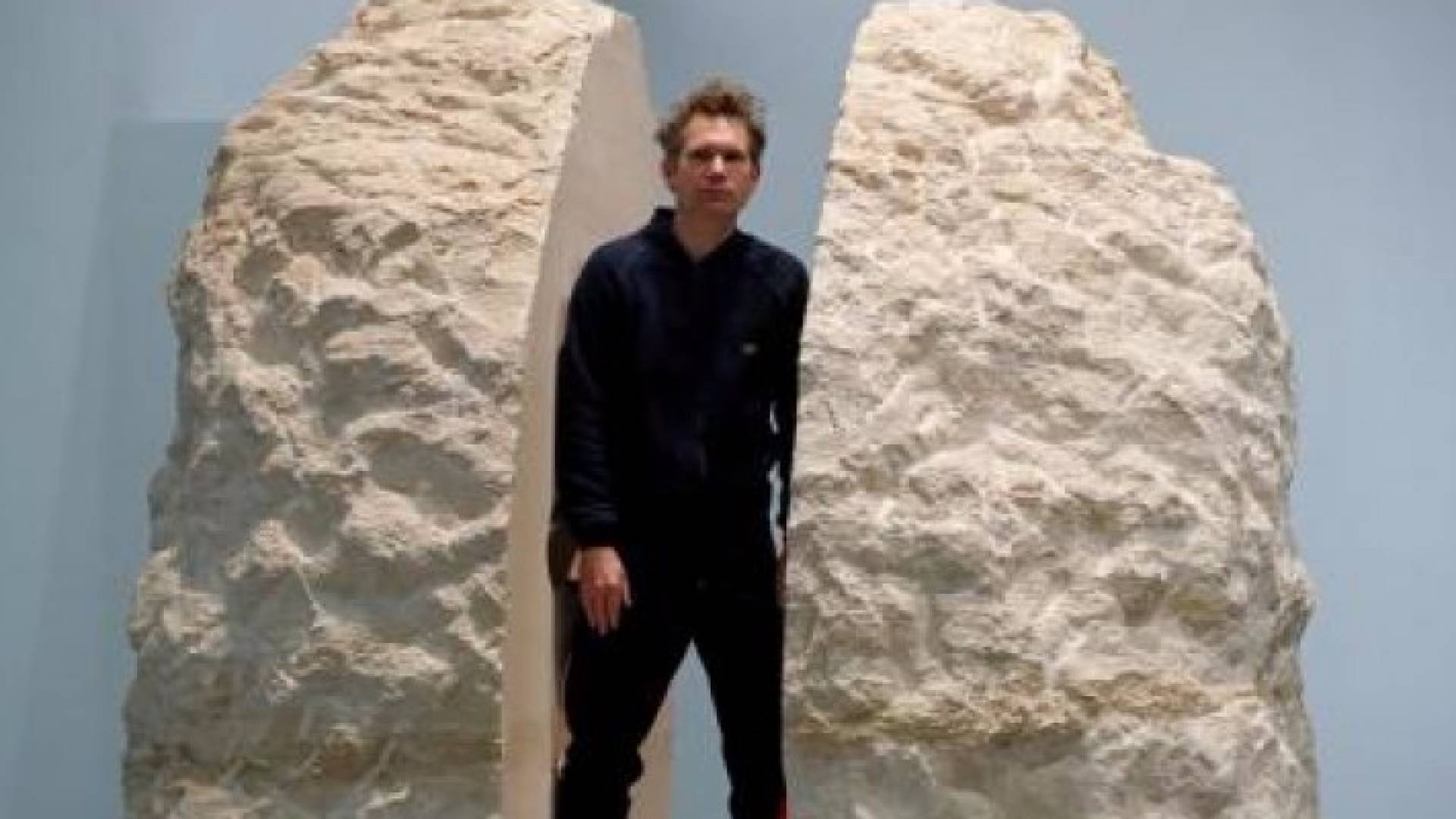 الفنان الفرنسي أبراهام بوانشيفال يقف لالتقاط صور مع كتلة من الحجر 