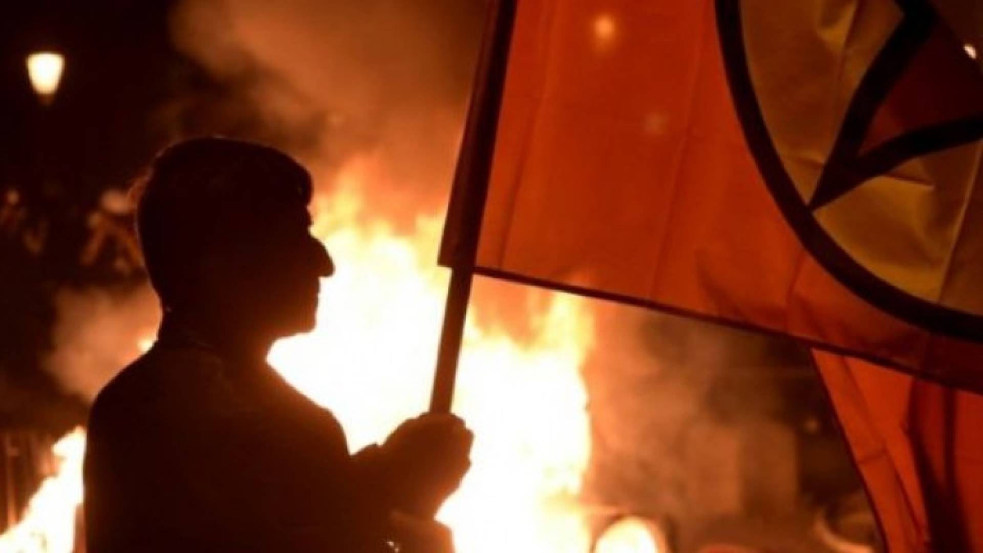 متظاهر يسير أمام حريق بعد تظاهرة ضد قمة مجموعة العشرين