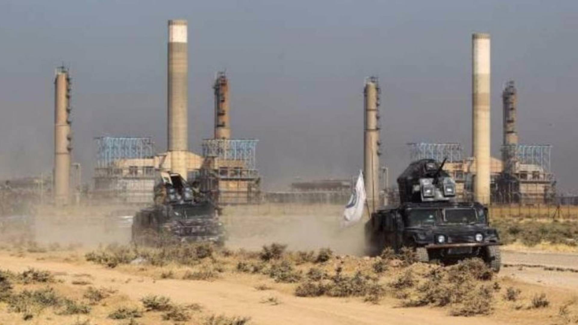 عربات عسكرية للجيش العراقي تمر أمام منشأة نفطية في كركوك