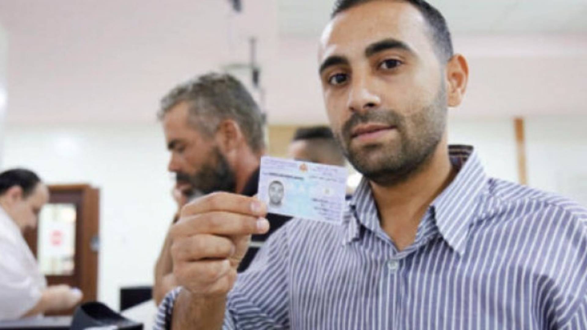 مواطن يحصل على بطاقته الذكية