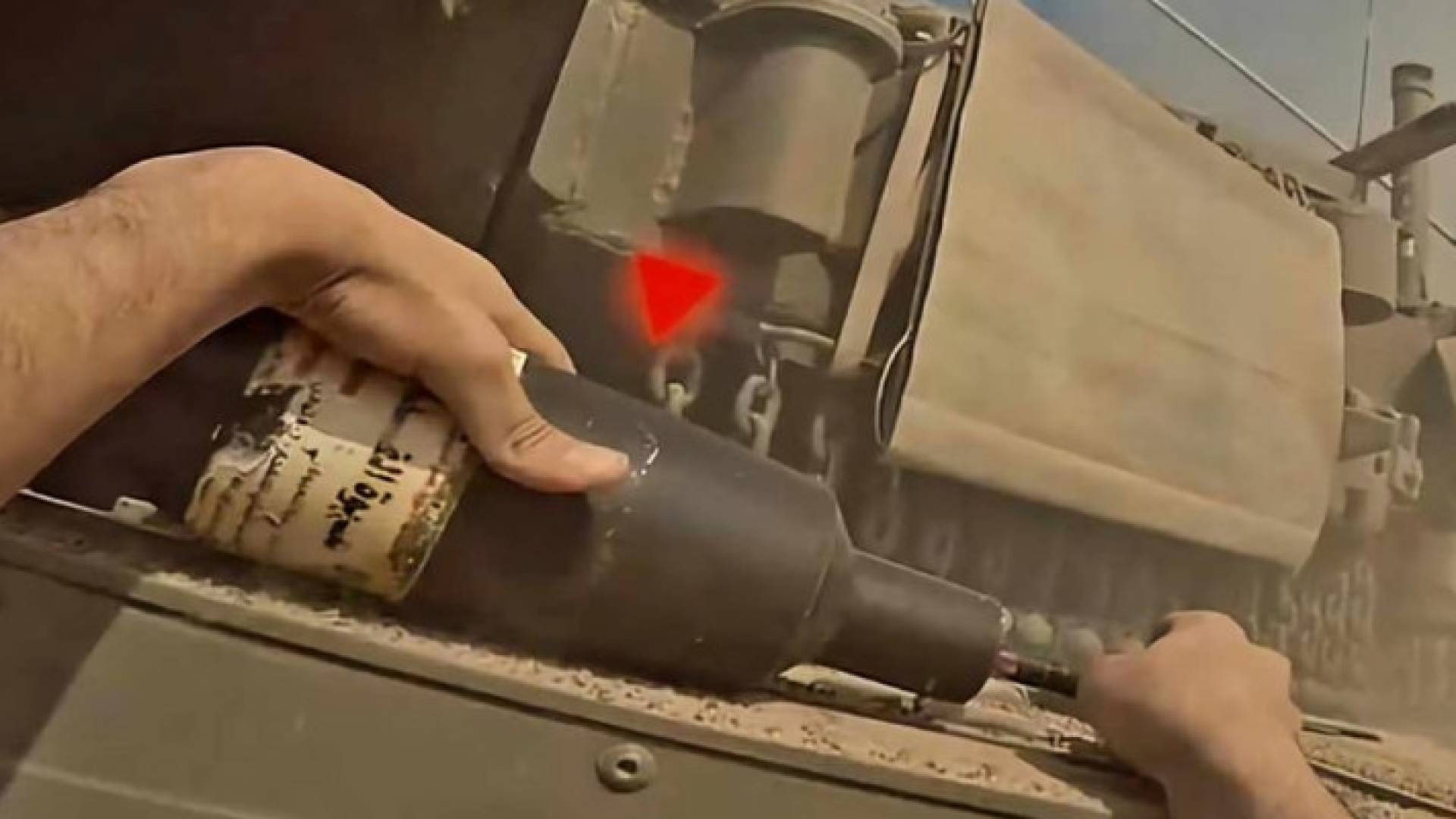 أحد عناصر القسام يضع قنبلة على دبابة ويظهر عليها المثلث الاحمر لتحديد الهدف