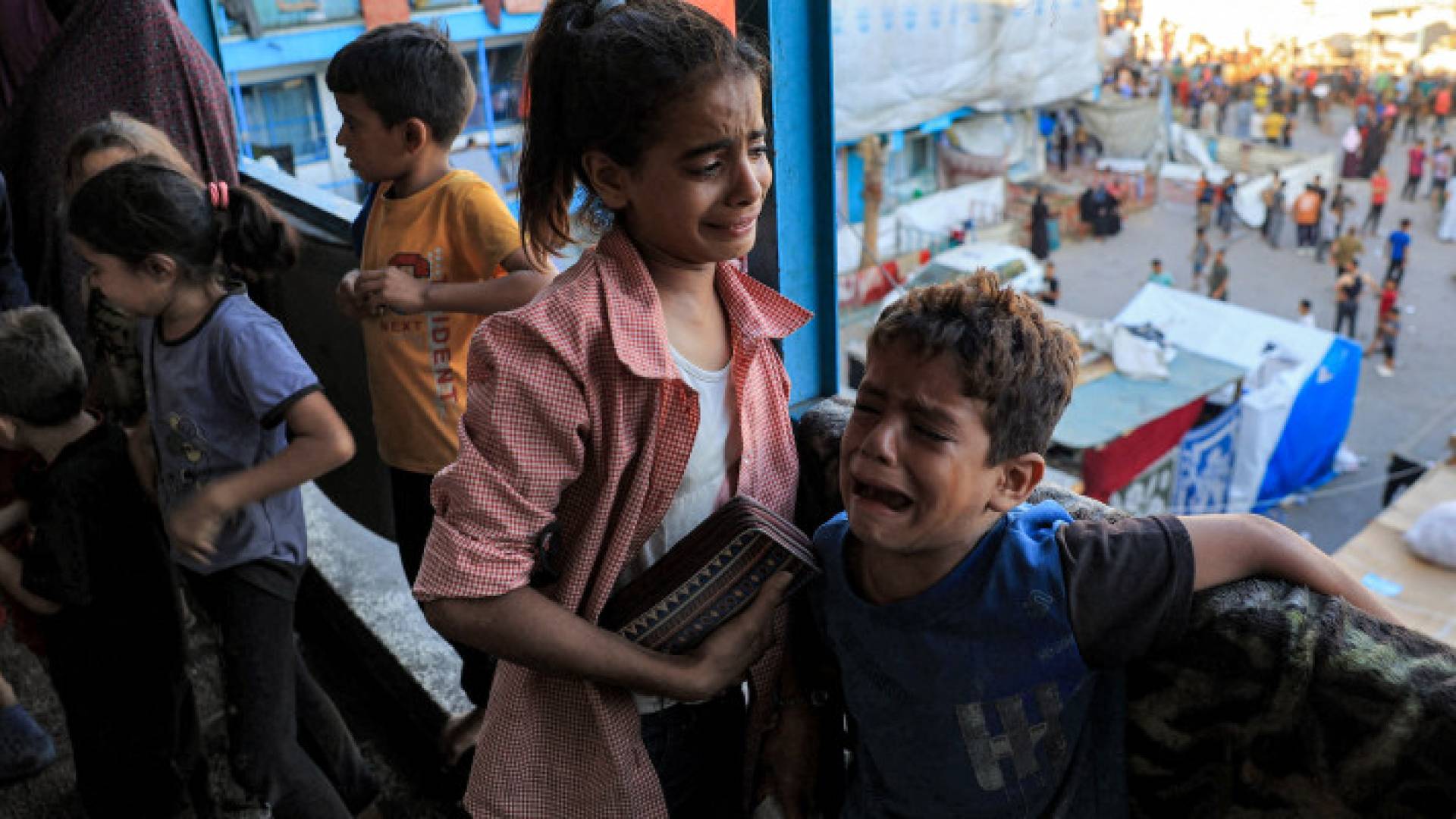 أطفال يبكون خوفا من جراء القصف المتواصل على مدارس تؤوي نازحين في غزة