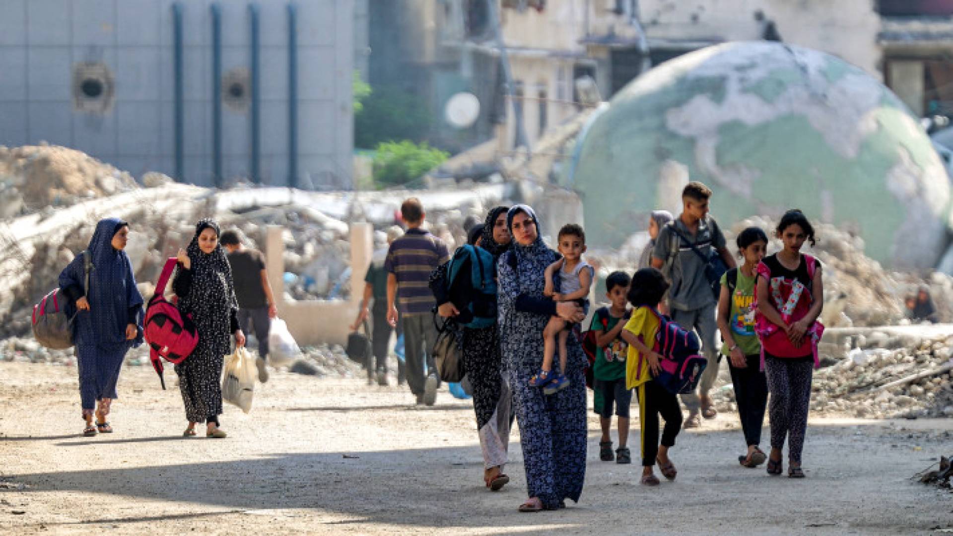 فلسطيميون يمرون من حي التفاح شرق مدينة غزة