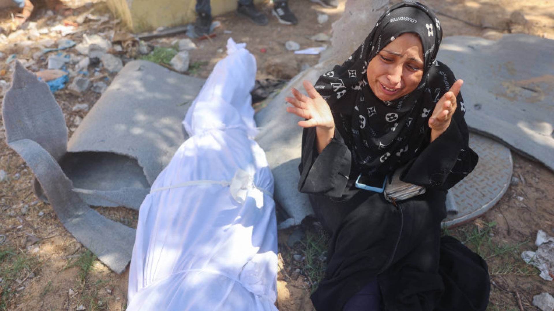 فلسطينية تبكي بجانب جثمان أحد أقاربها الذي استشهد في مجزرة المواصي بقطاع غزة