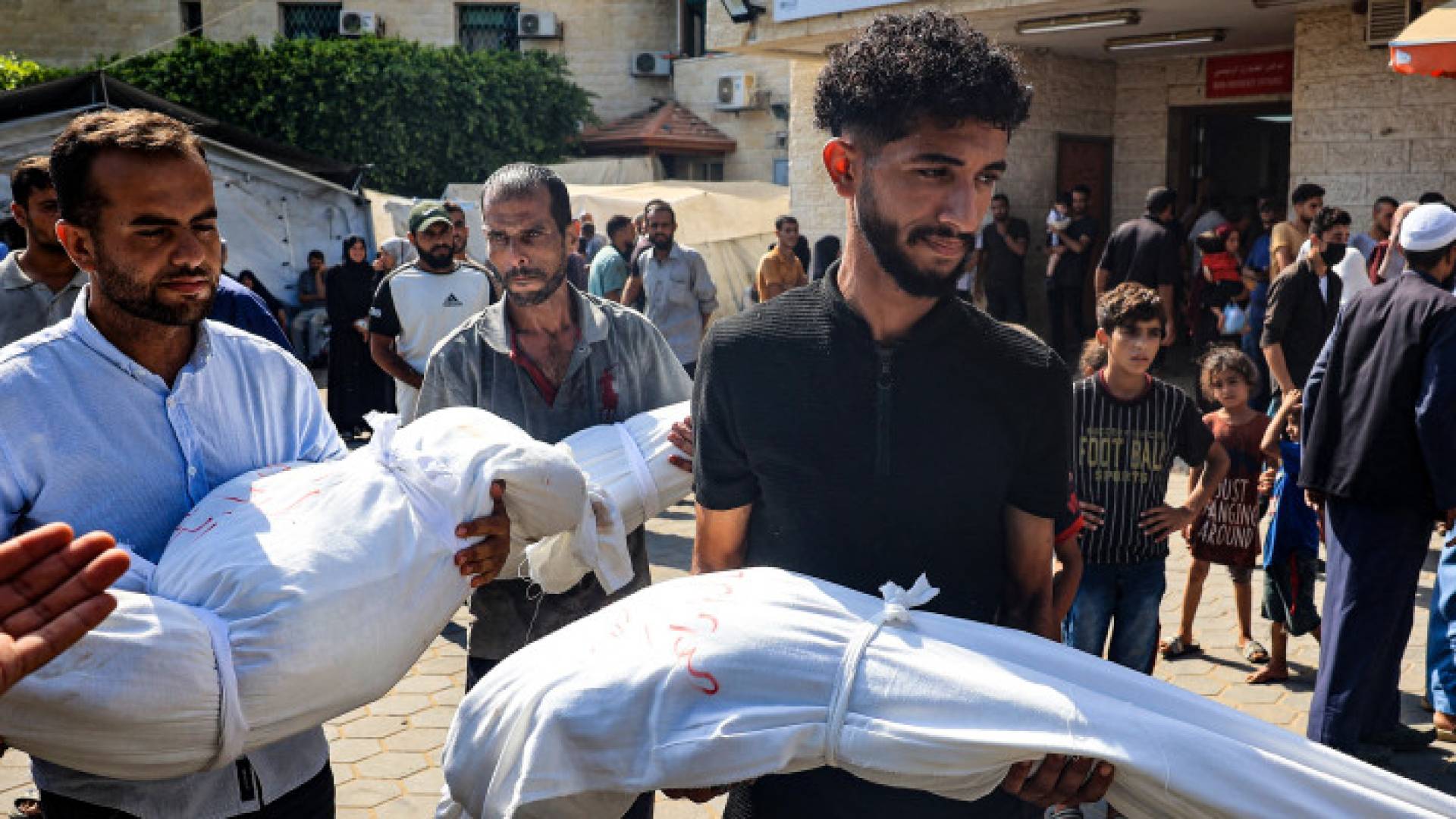 فلسطينيان يحملان جثتي طفليهما في غزة