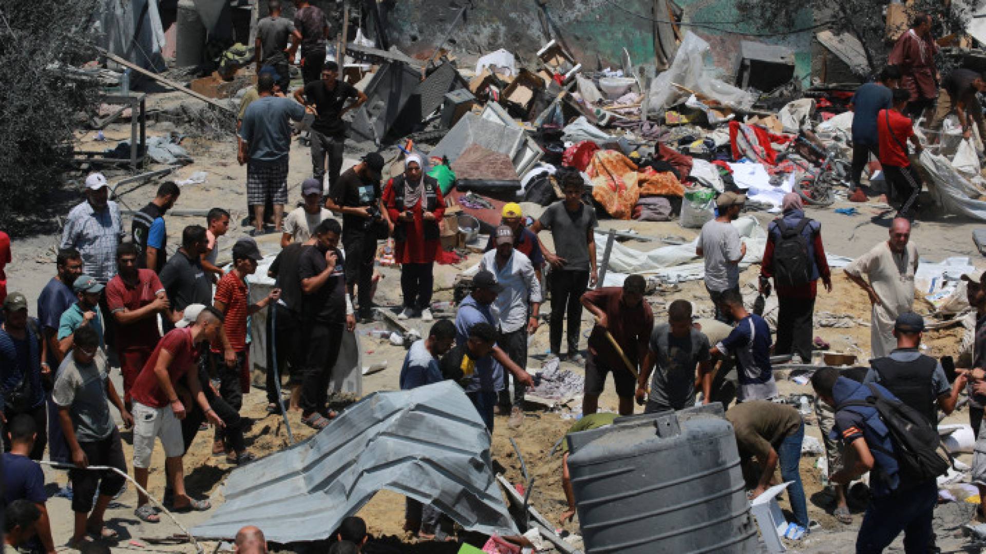 فلسطينيون يبحثون عن أحبائهم بين أنقاض الخيام في أعقاب غارة عسكرية للاحتلال على مخيم المواصي للنازحين