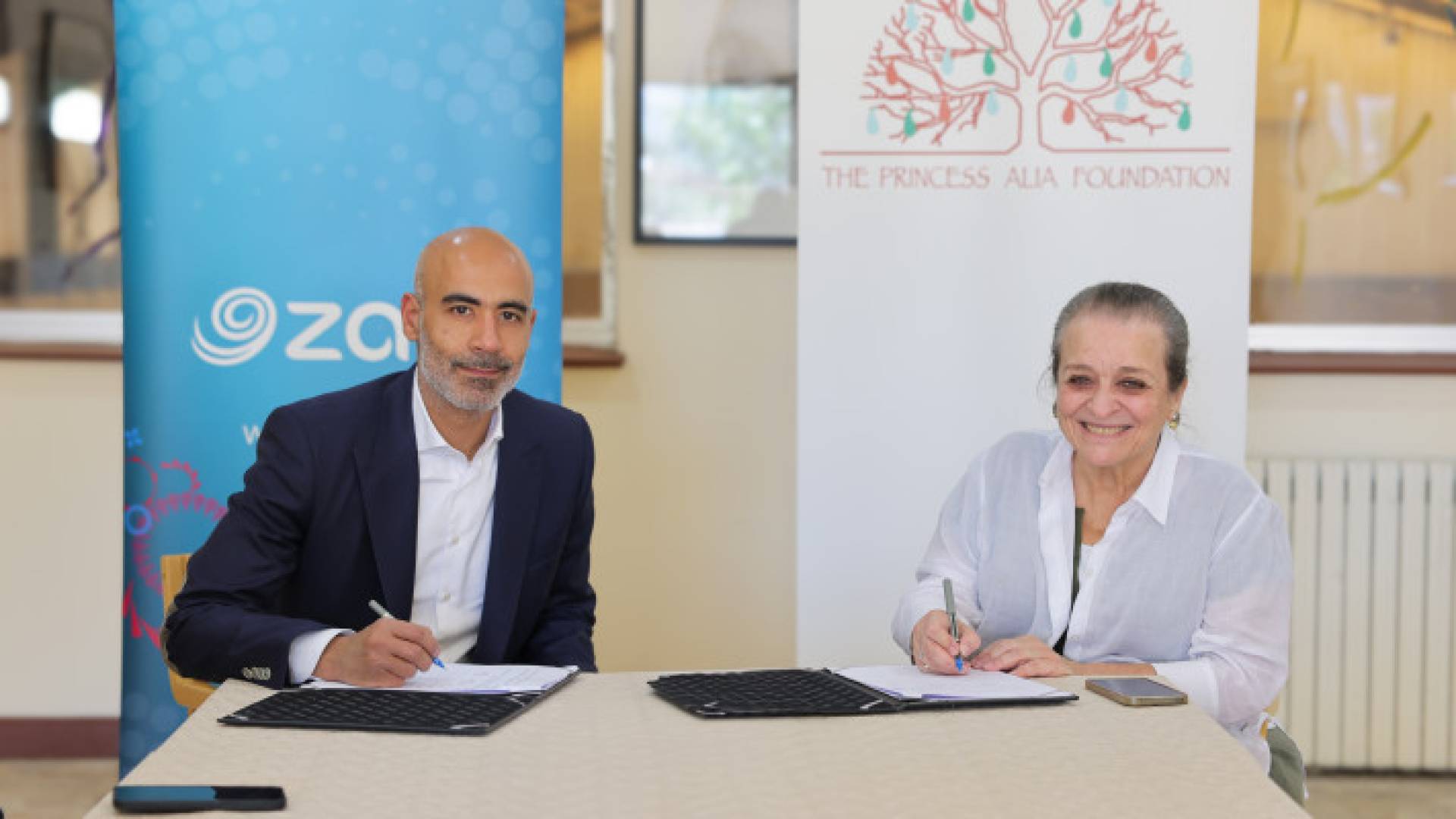 سمو الأميرة عالية بنت الحسين وعن شركة زين الأردن رئيسها التنفيذي فهد الجاسم يوقعان على الاتفاقية