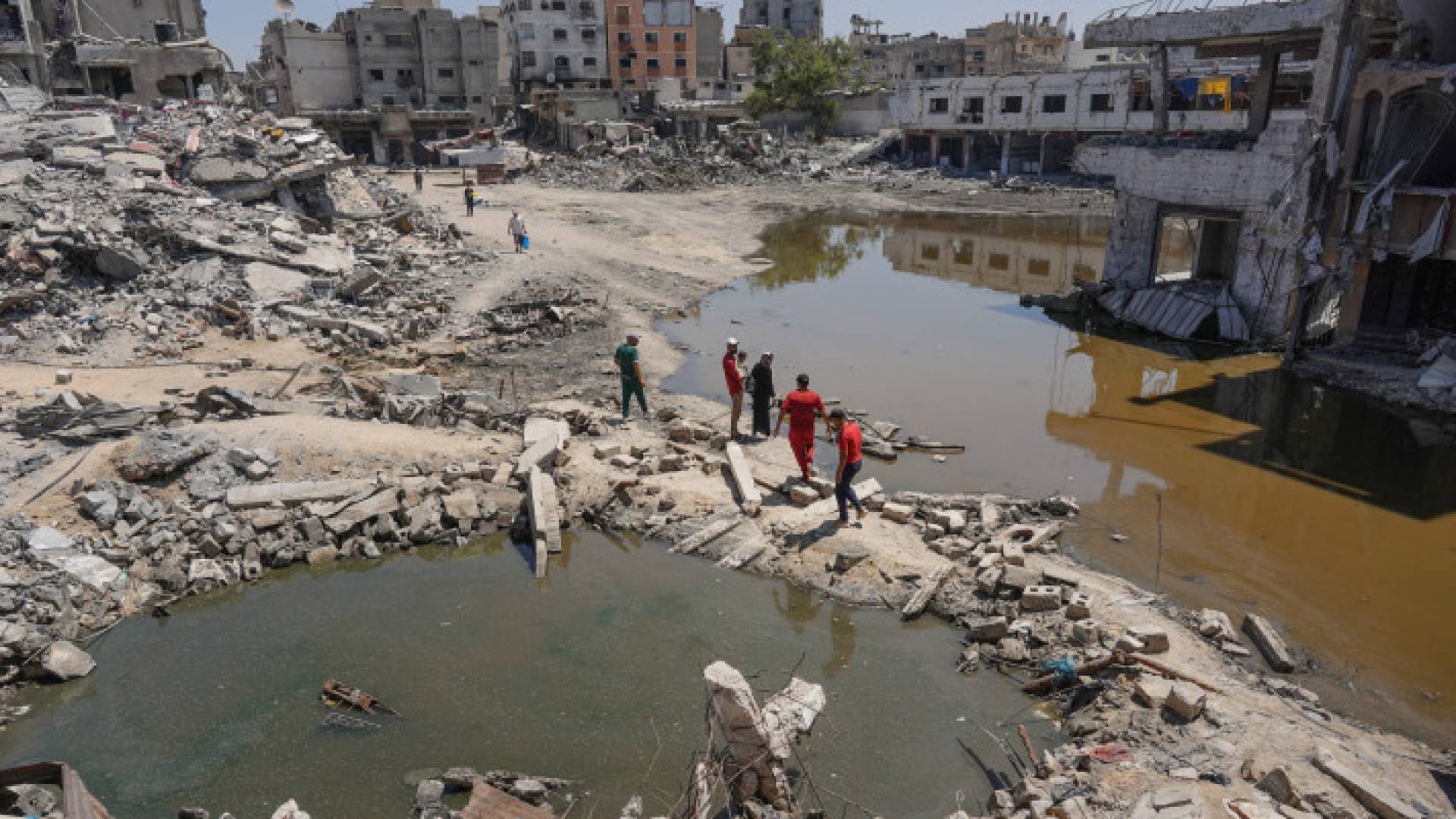 فلسطينيون بين أنقاض المباني المدمرة جراء قصف الاحتلال في خان يونس جنوب القطاع