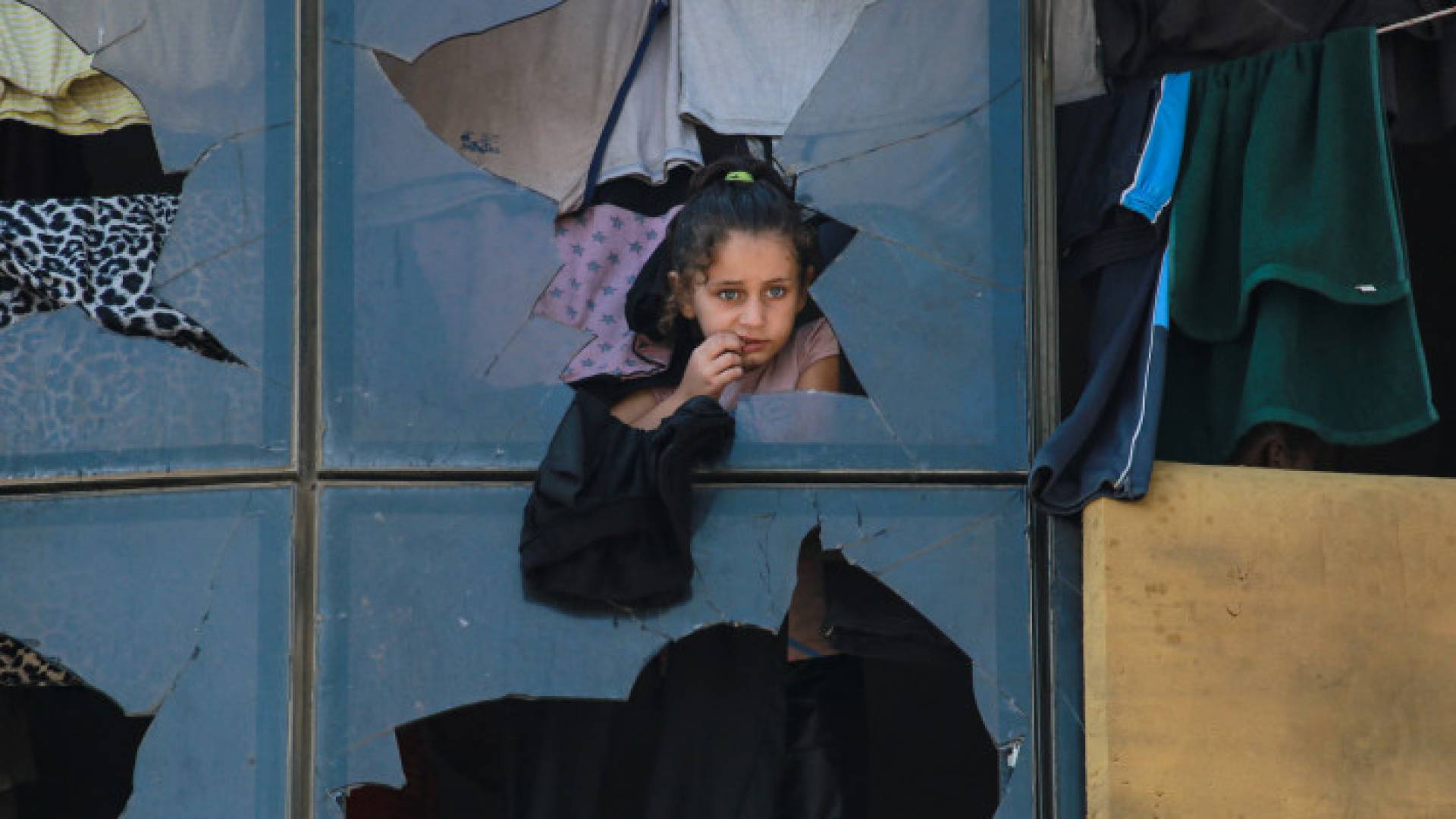 طفلة فلسطينية تقف داخل مبنى مكسور في مخيم للنازحين في خان يونس - AFP