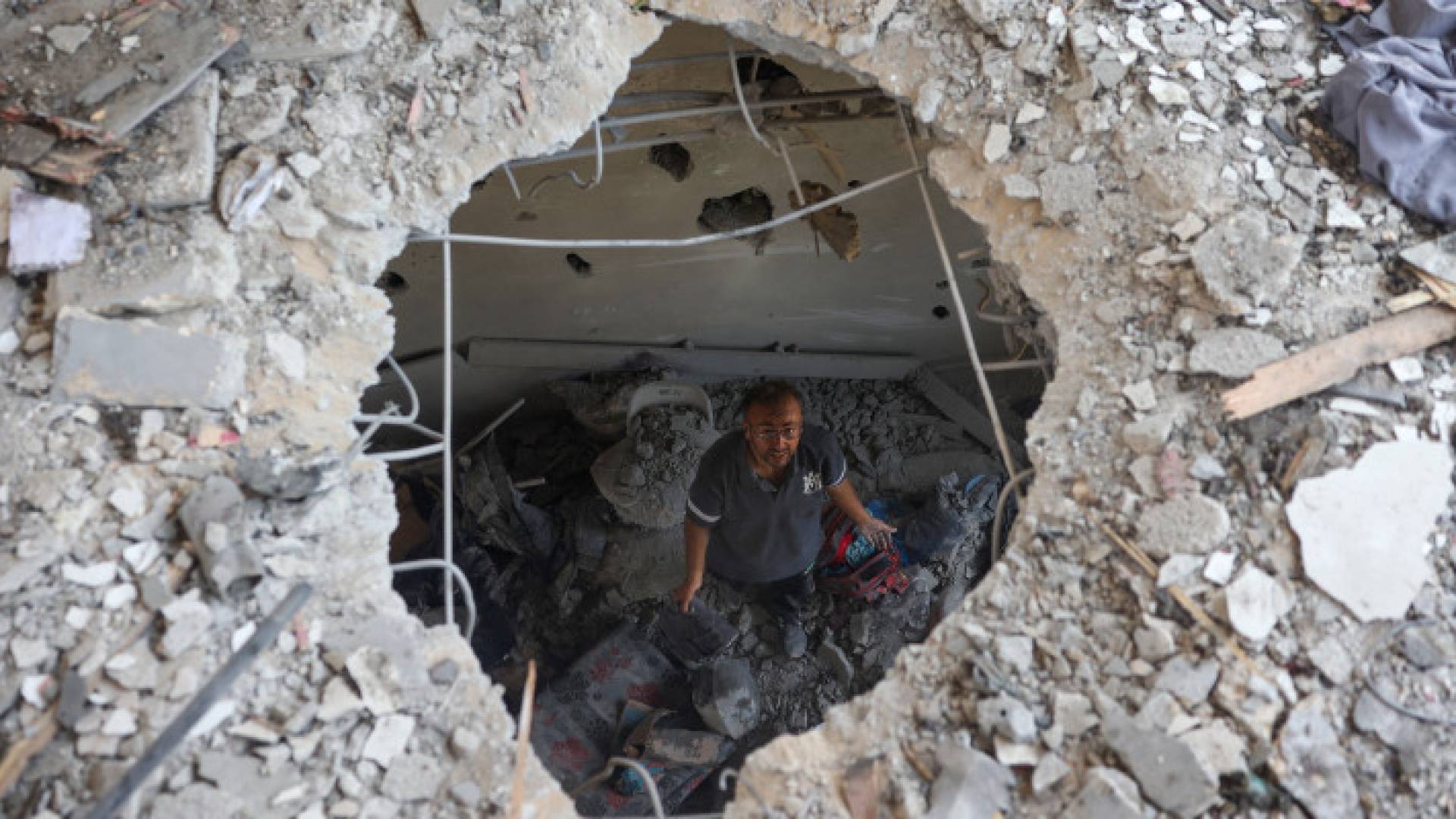 فلسطيني يتفقد الأضرار الناجمة عن غارة للاحتلال على مدرسة خديجة التي تؤوي النازحين في دير البلح