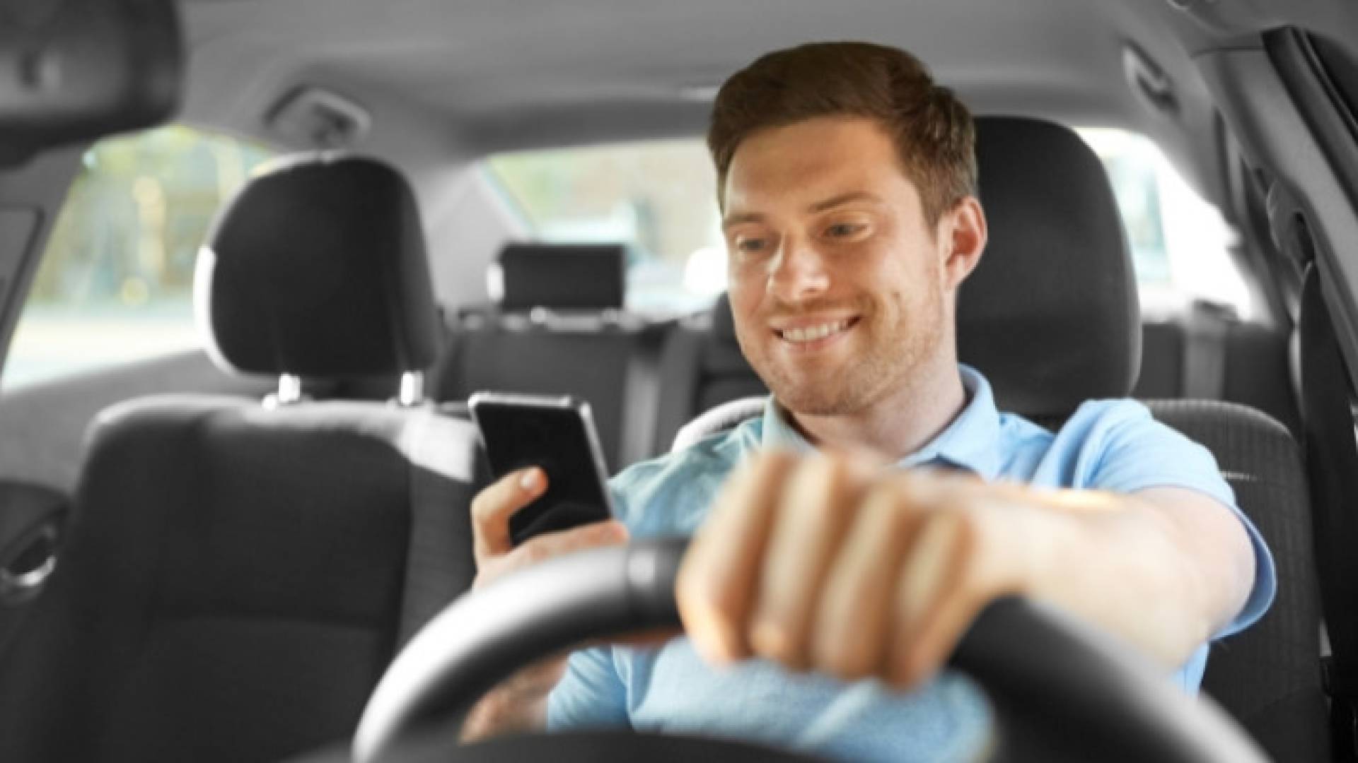 شخص يستخدم الهاتف أثناء القيادة - تعبيرية