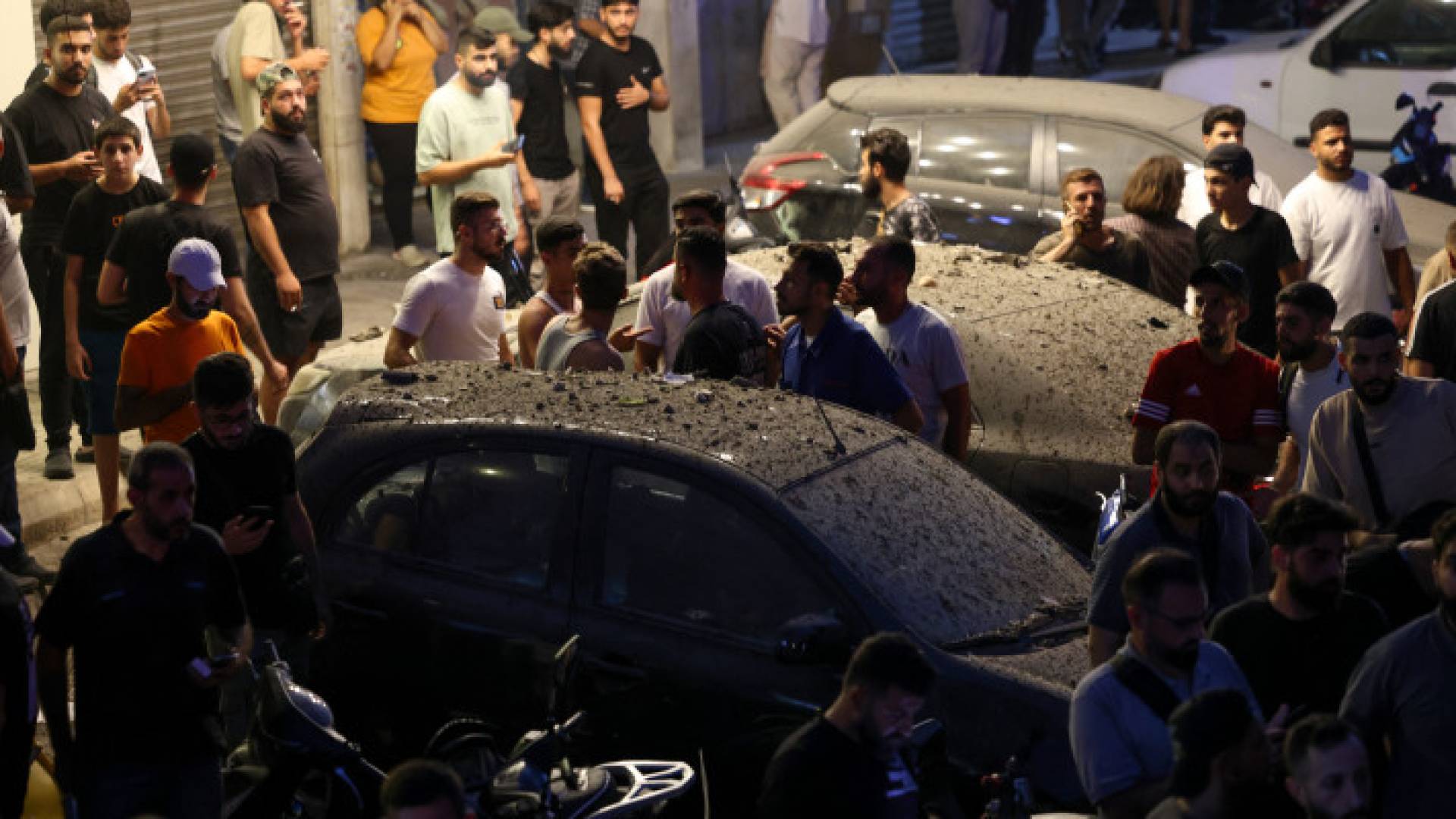 أشخاص يتجمعون بالقرب من المبنى الذي استهدفته مسيرة تابعة للاحتلال في بيروت