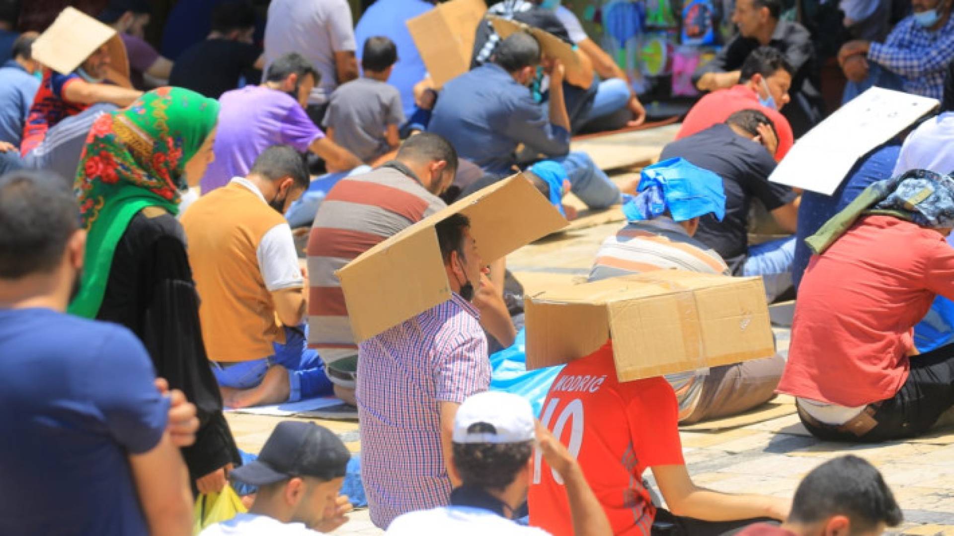 أردنيون يستظلون أثناء صلاة الجمعة من حرارة الشمس - أرشيف