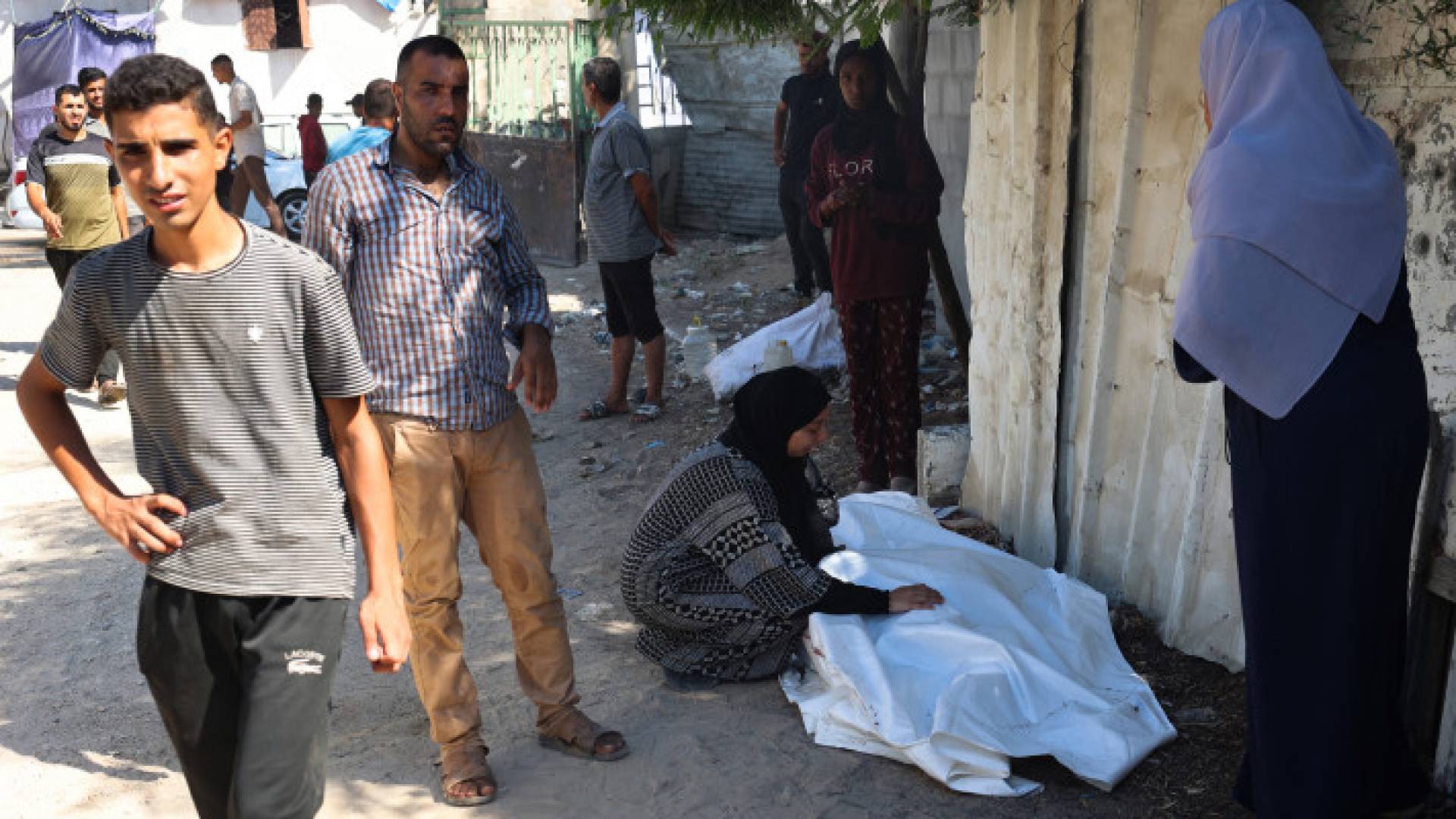 فلسطينيون بالقرب من جثمان أحد الشهداء في مخيم البريج وسط قطاع غزة