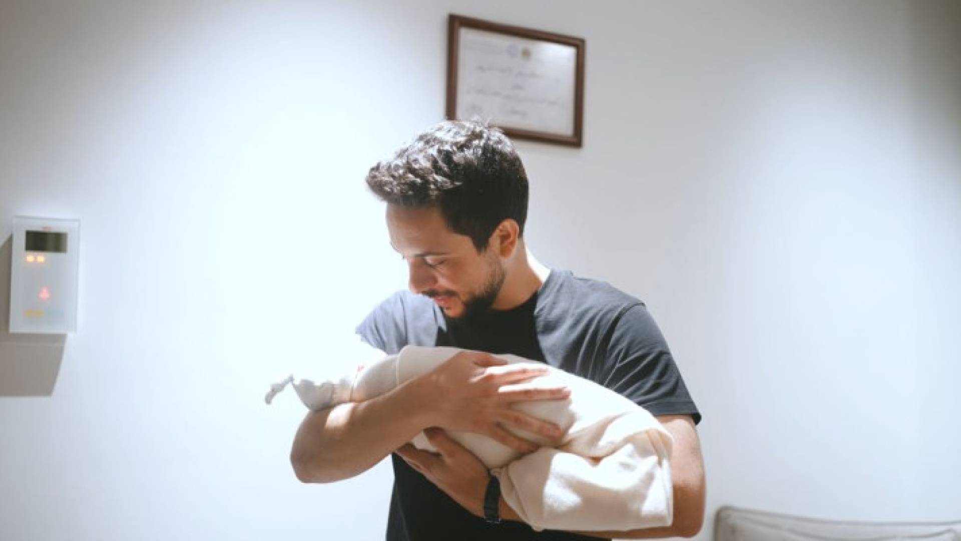 سمو الأمير الحسين وهو يؤذن في أذن مولودته سمو الأميرة إيمان