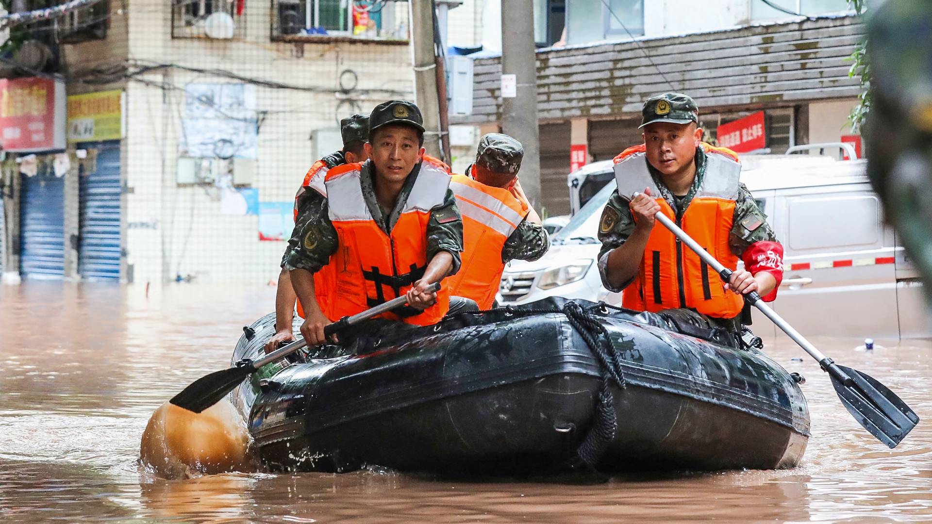 رجال الشرطة شبه العسكرية يبحثون في منطقة غمرتها مياه الأمطار الغزيرة في تشونغتشينغ بجنوب غرب الصين في 4 يوليو
