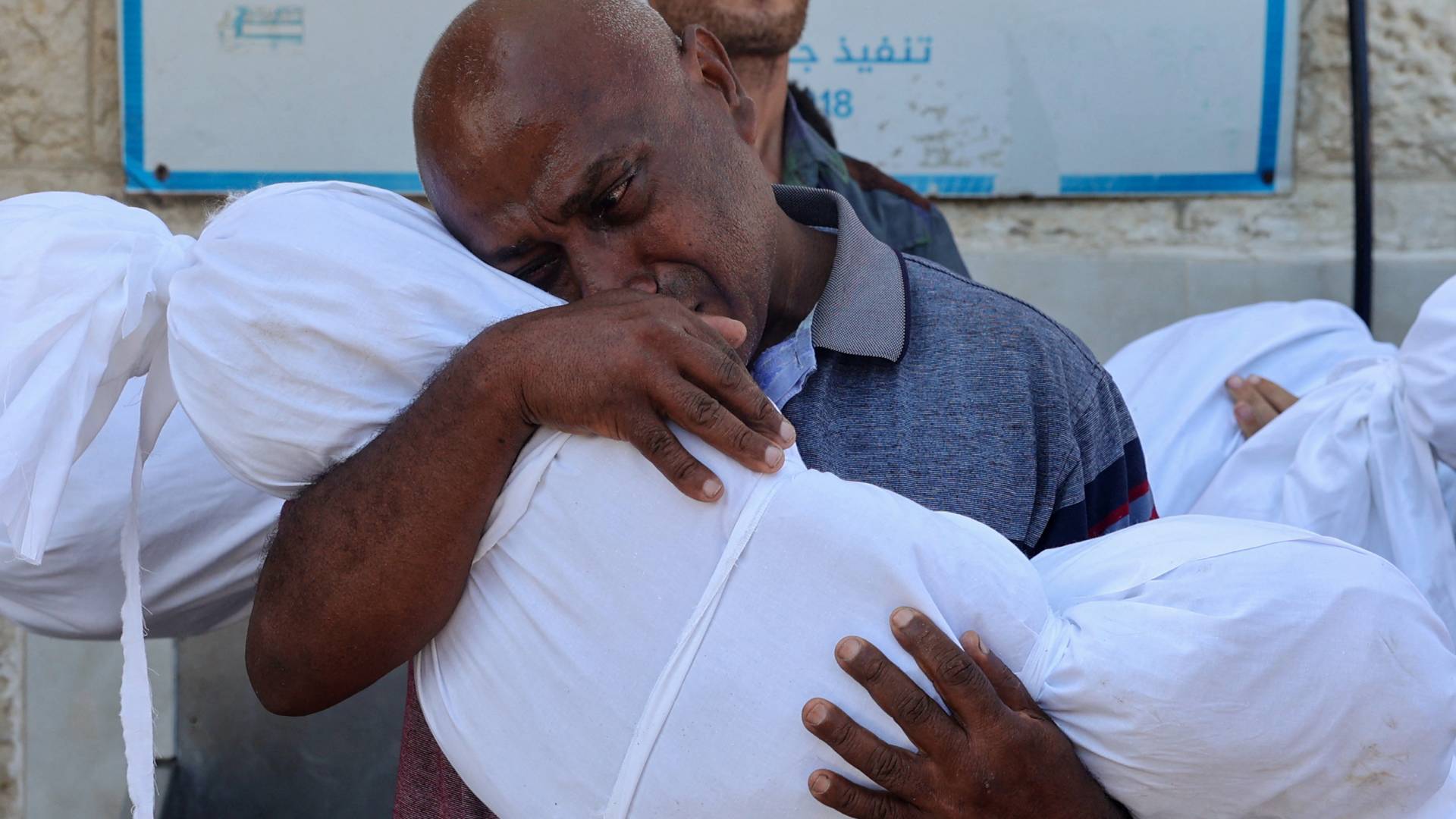 أب يحتضن جثمان نجله الشهيد في غزة "أ ف ب"