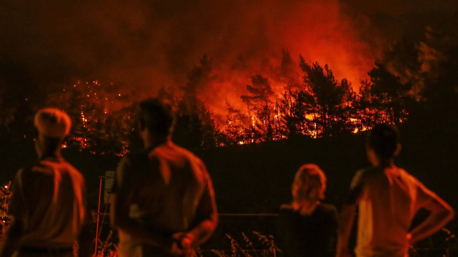 سكان يراقبون اللهب والدخان يتصاعدان فوق الأشجار بالقرب من إزمير