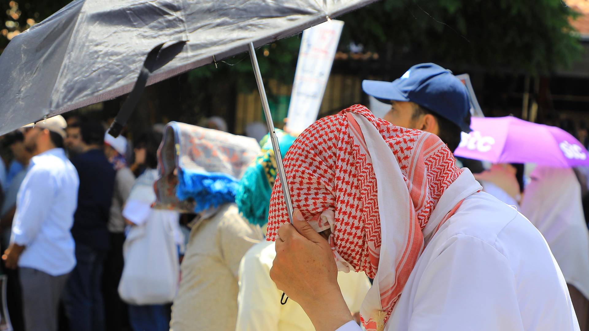 شخص يحمل مظلة للوقاية من أشعة الشمس