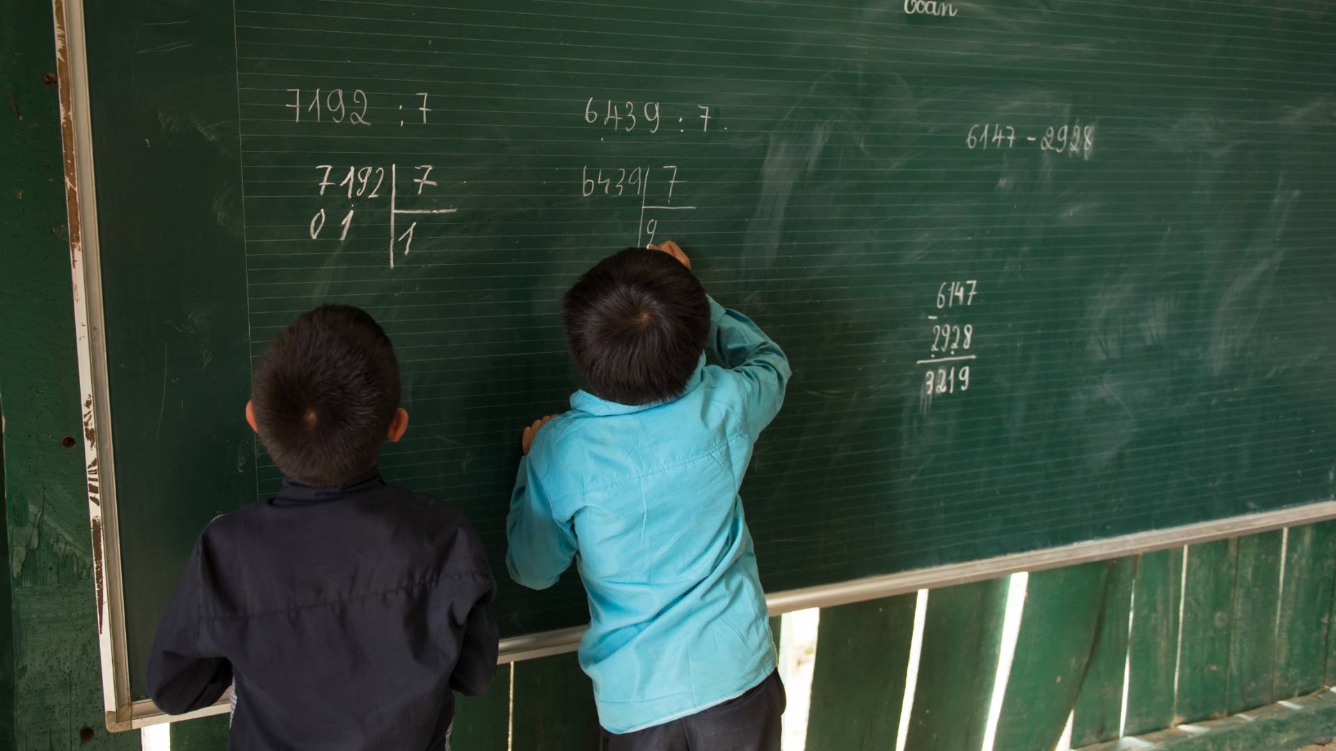 طالبان يكتبان على الصبورة