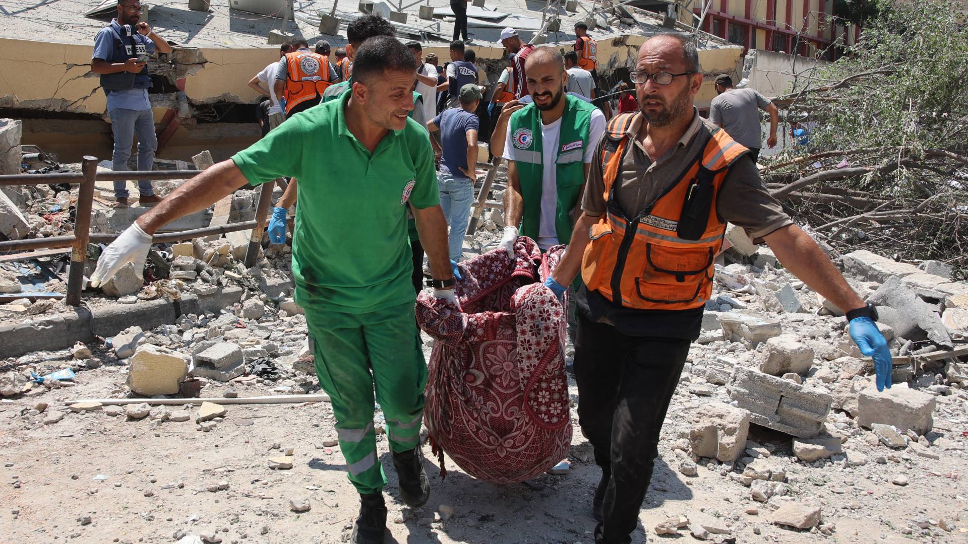 مسعفون يحملون جثمان أحد الشهداء في حي الرمال بوسط مدينة غزة