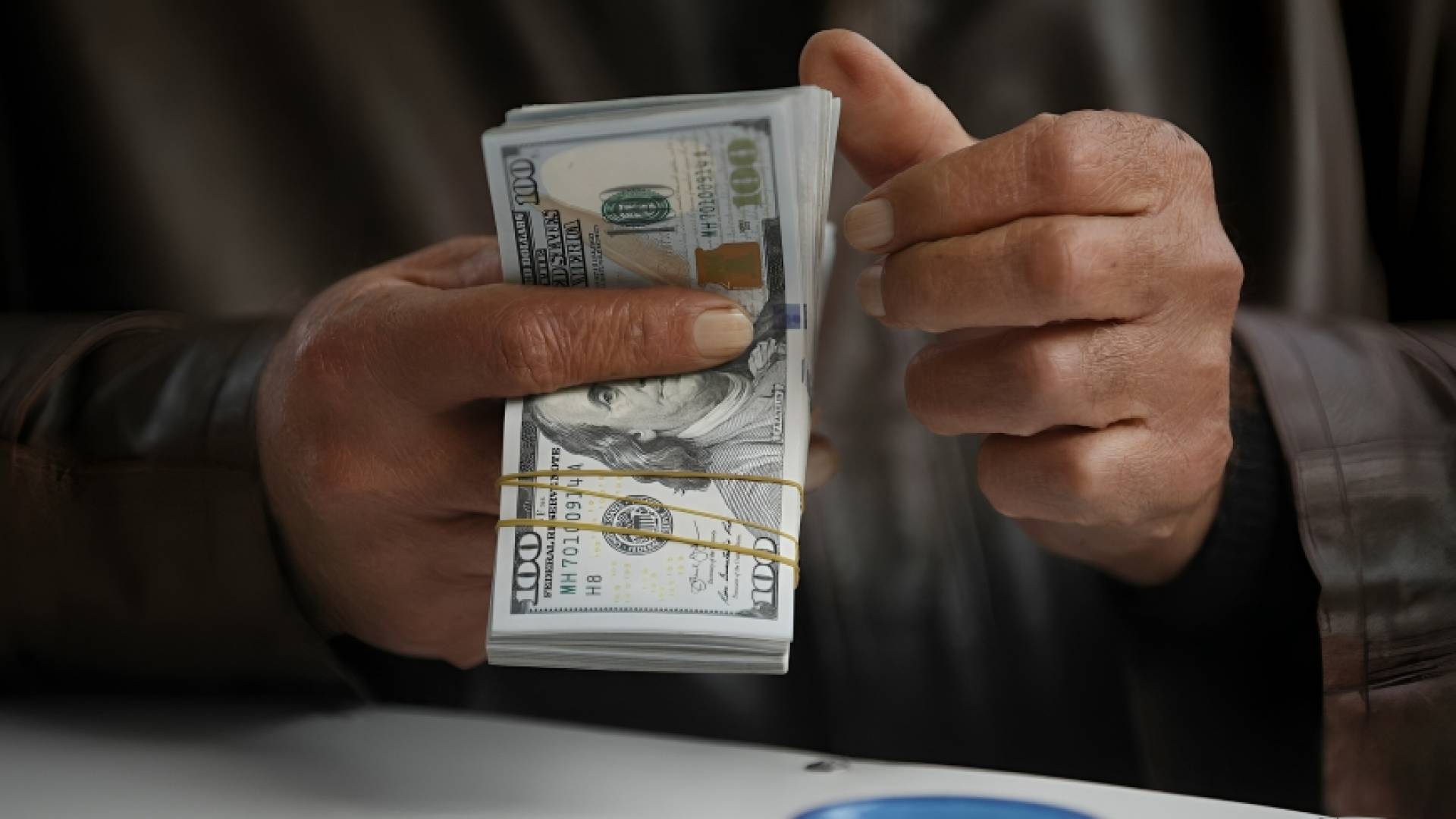 رجل يحمل حزمة من عملة الدولار
