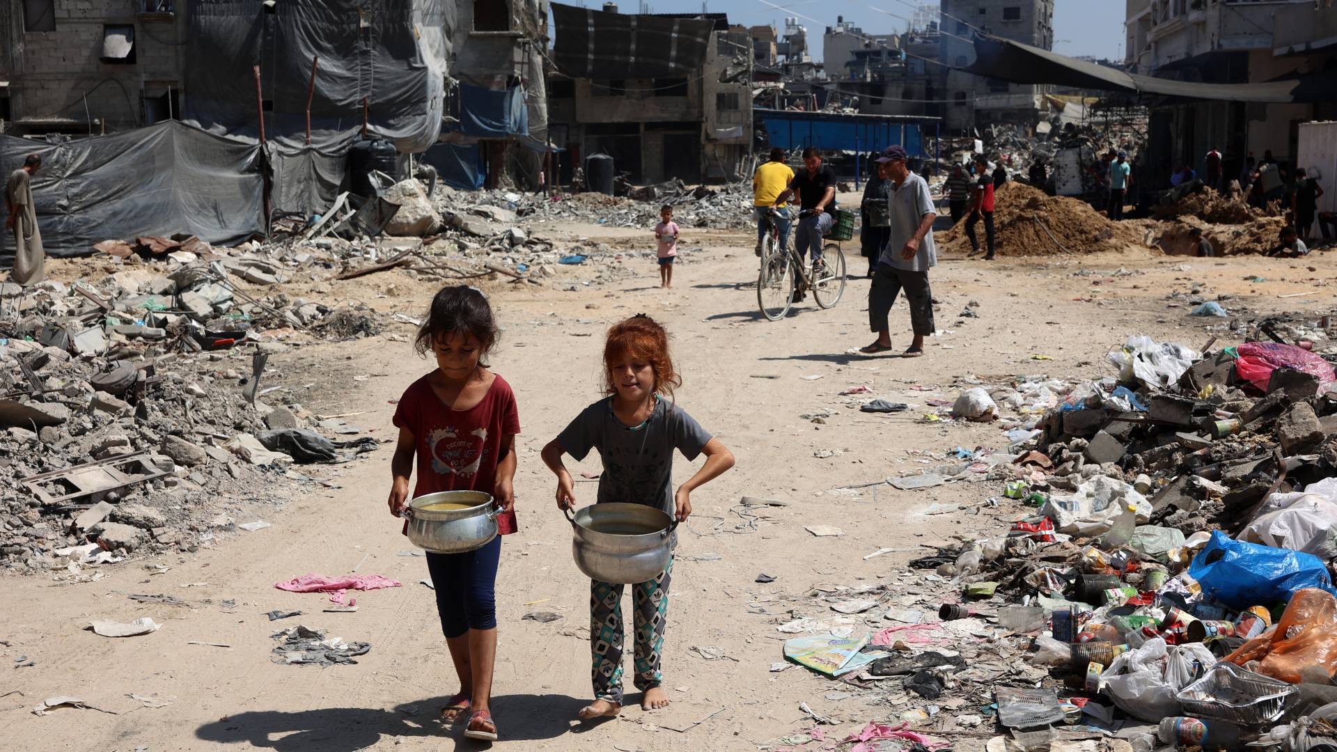 فلسطينيتان تحملان أواني حساء في مخيم جباليا شمال قطاع غزة