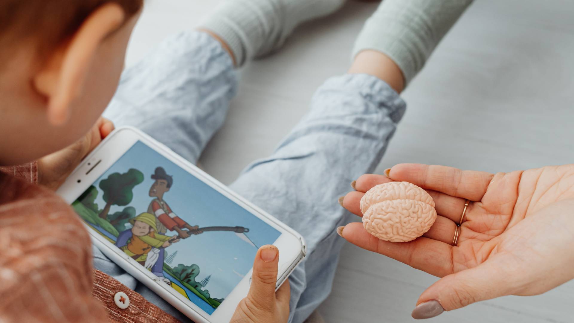 صورة تبين طفلاً يستخدم هاتفًا ذكيًا