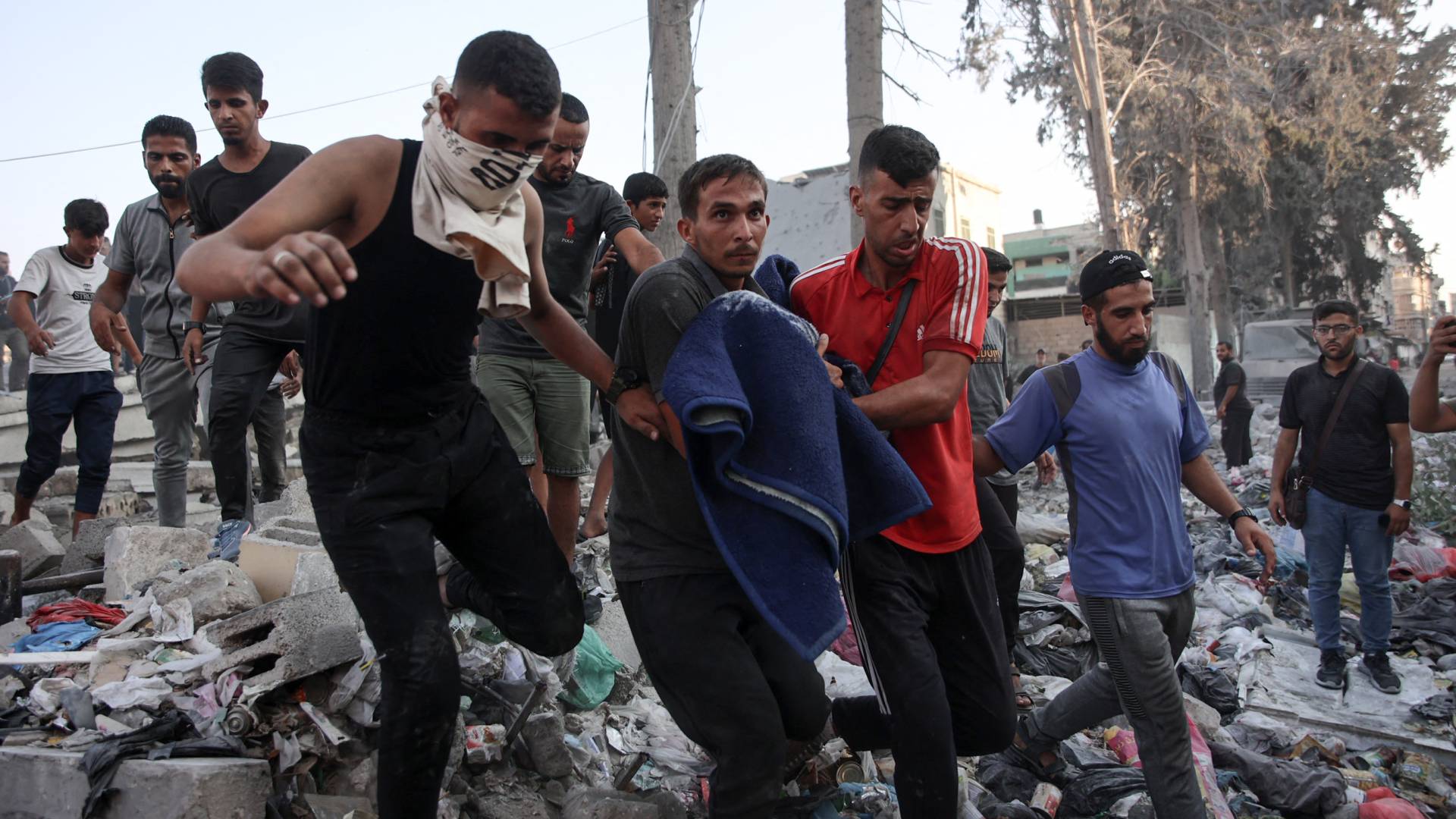 فلسطينيون يحملون جثمان شهيد بعد غارة للاحتلال استهدفت مدرسة في حي الزيتون