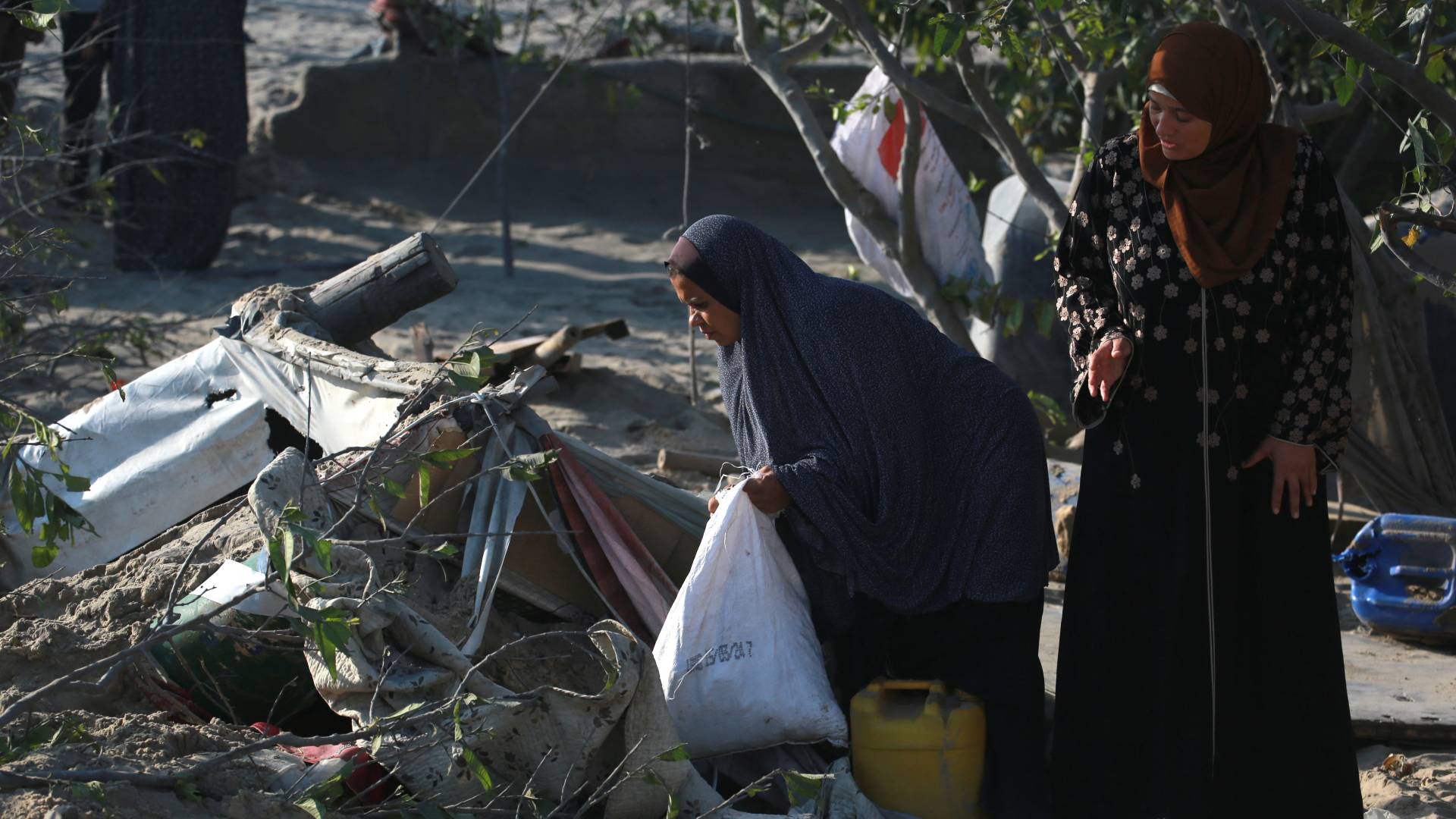 فلسطينيتان في موقع المجزرة التي ارتكبها الاحتلال في مواصي خان يونس