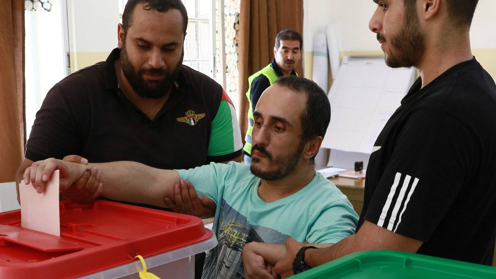 مساعدة مرشح لإدلاء صوته في الانتخابات النيابية