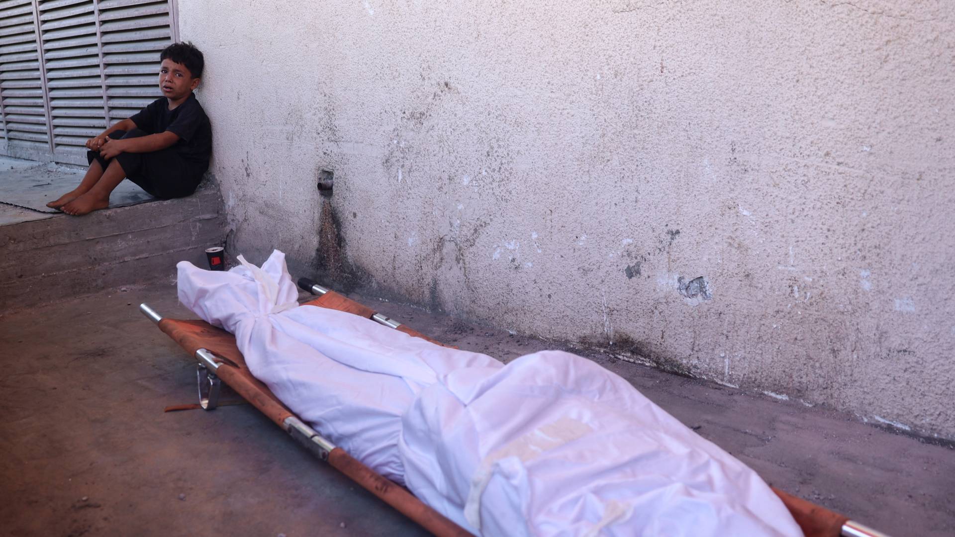 طفل يبكي بالقرب من جثمان أحد أفراد عائلته في غزة