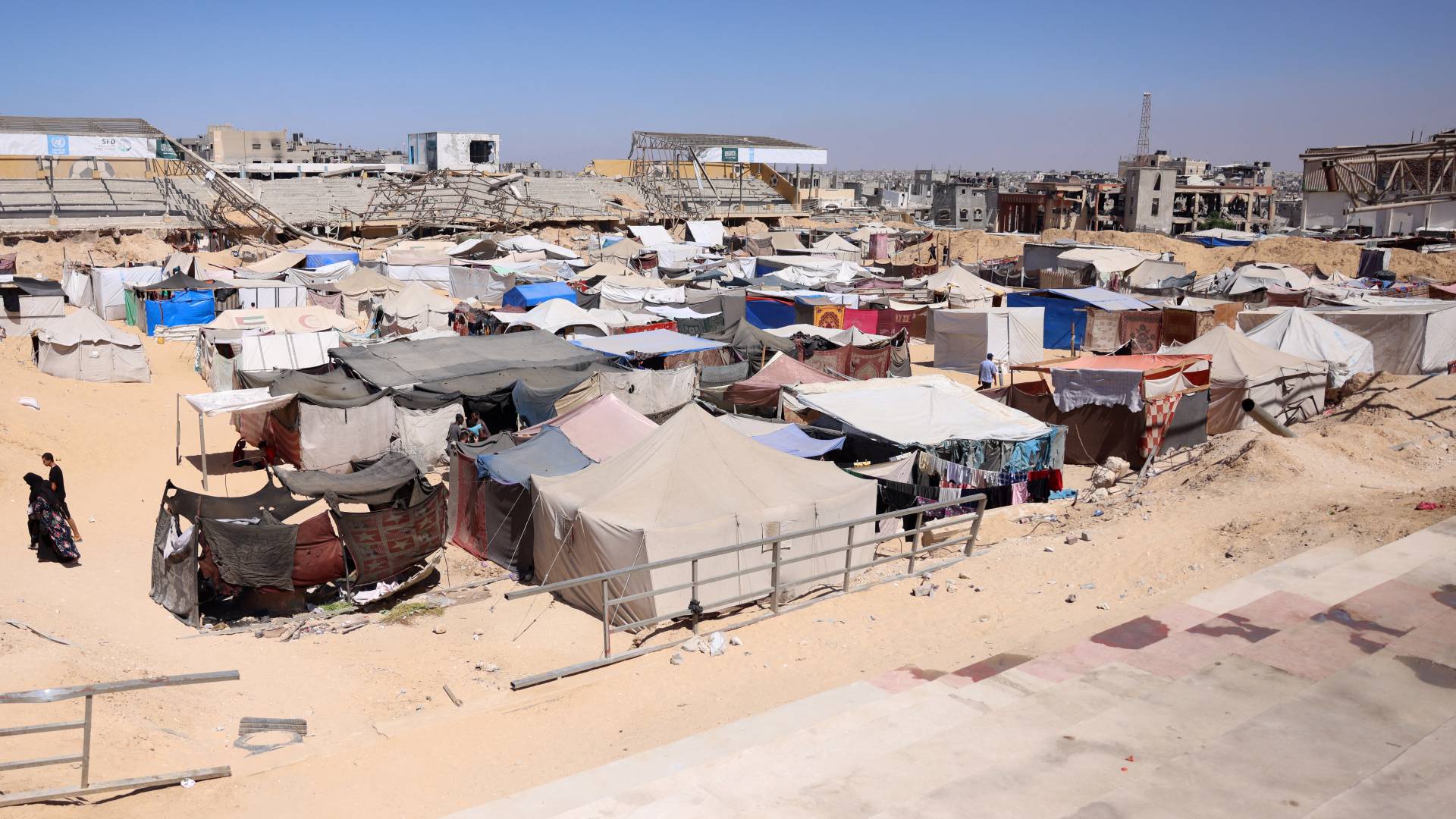 فلسطينيون نازحون يمشون في مخيم للنازحين في خان يونس جنوب القطاع