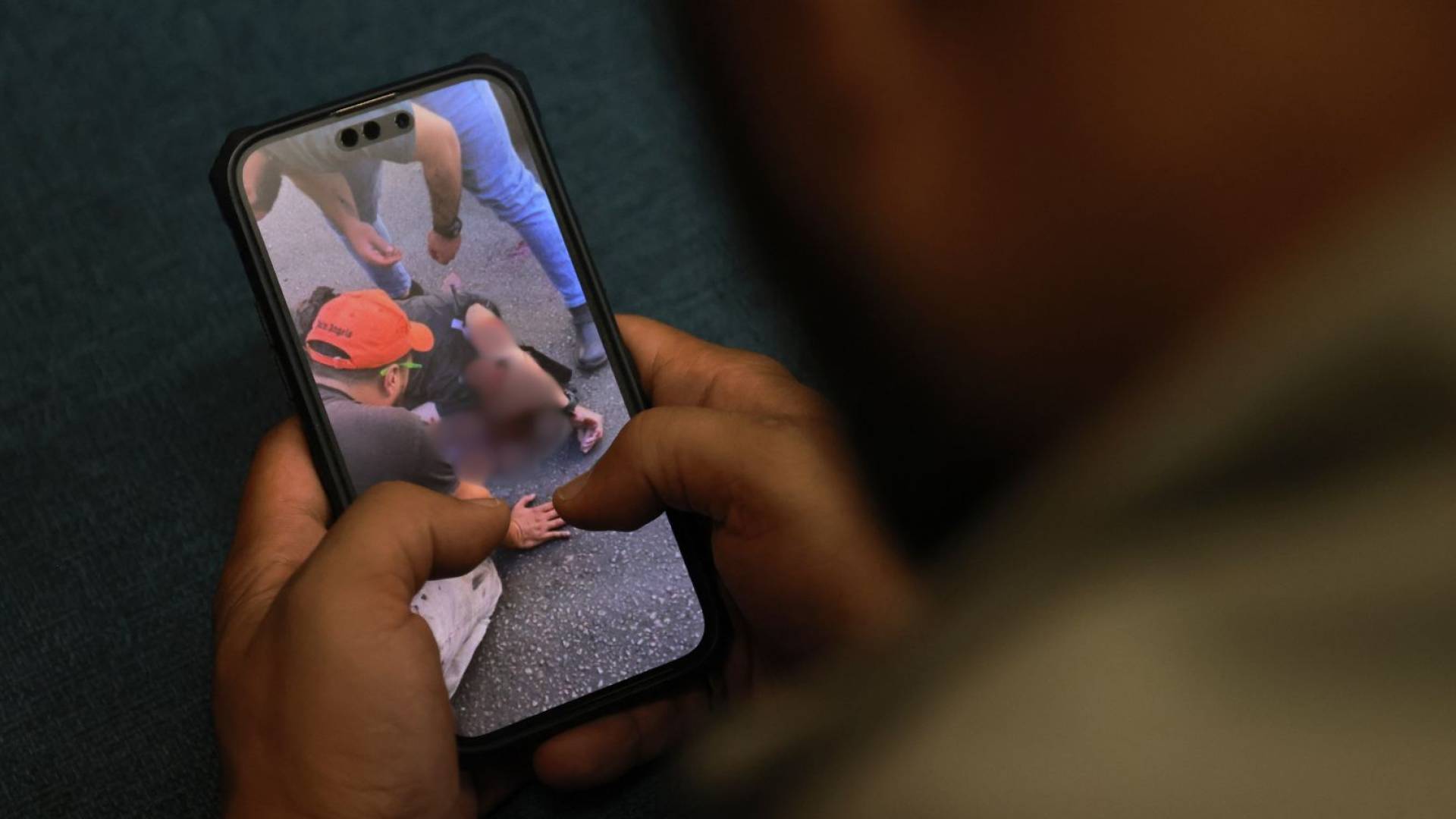 شخص يشاهد مقطع فيديو نشر على التواصل الاجتماعي لرجل جريح