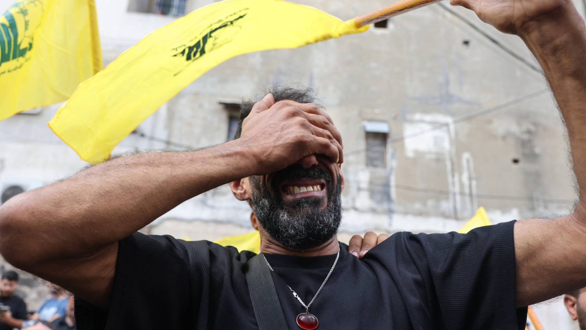 شخص يرفع شعار حزب الله أثناء تشييع جثمان أحد عناصر الحزب